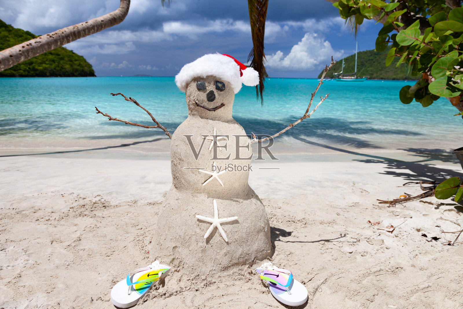 加勒比热带海滩上戴着圣诞帽的雪人照片摄影图片