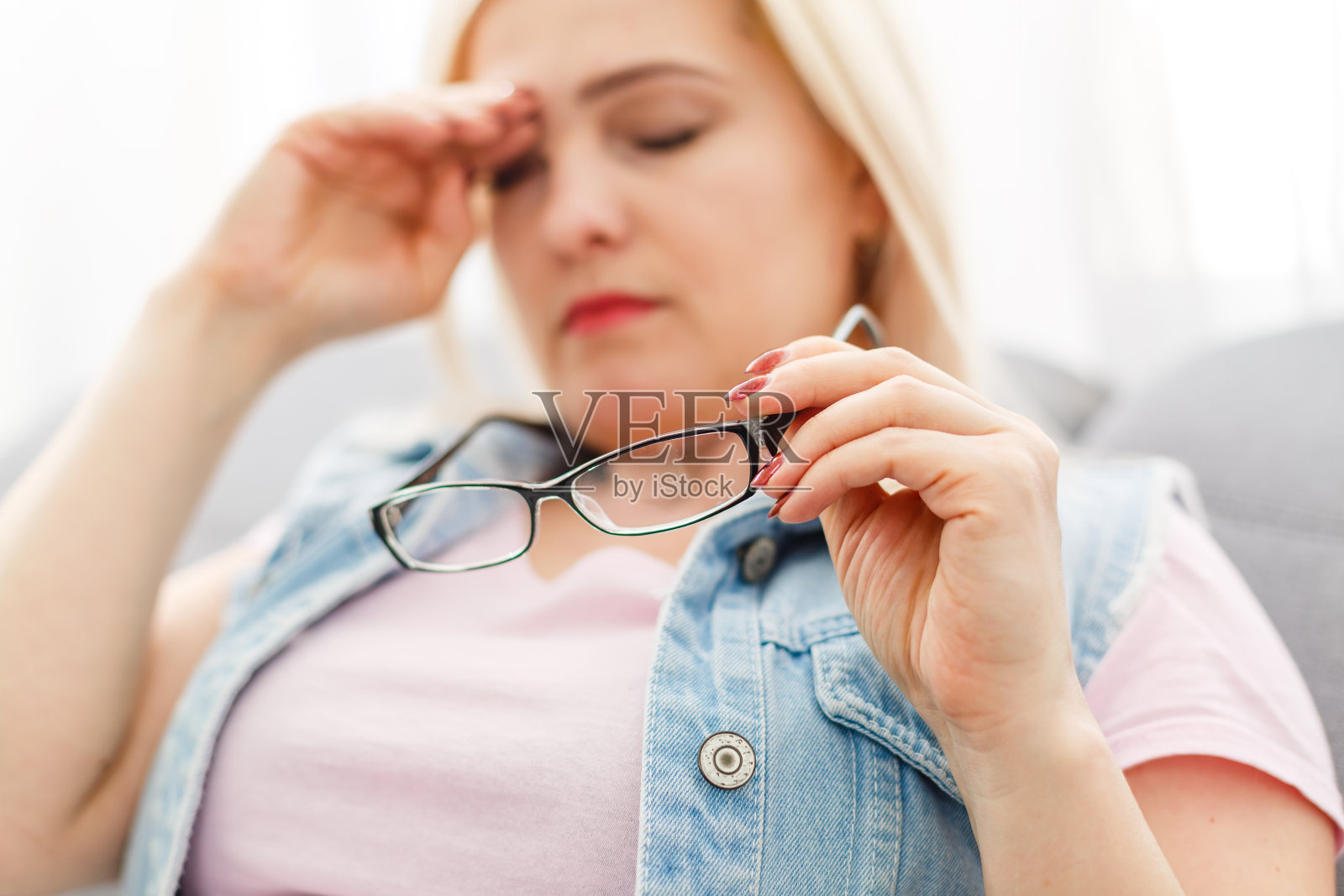 打哈欠的女人坐在家里的沙发上照片摄影图片