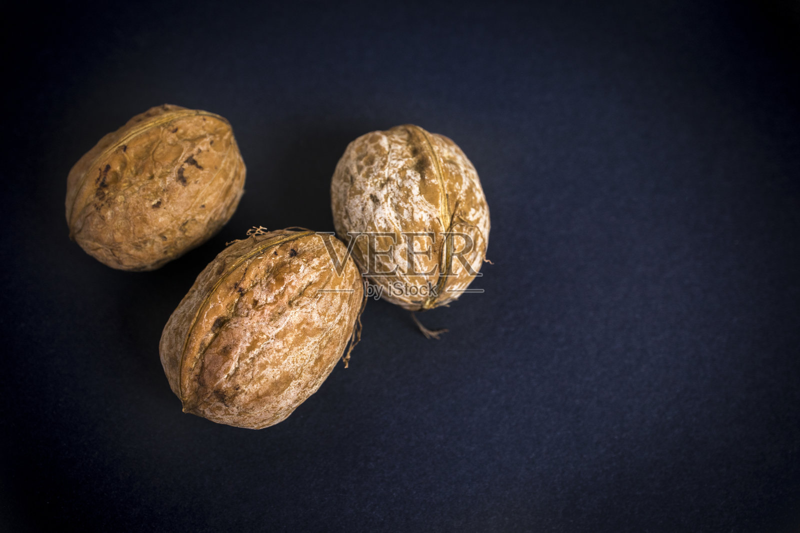 三个核桃被孤立在黑色的背景上。坚果。健康食品。特写镜头。照片摄影图片