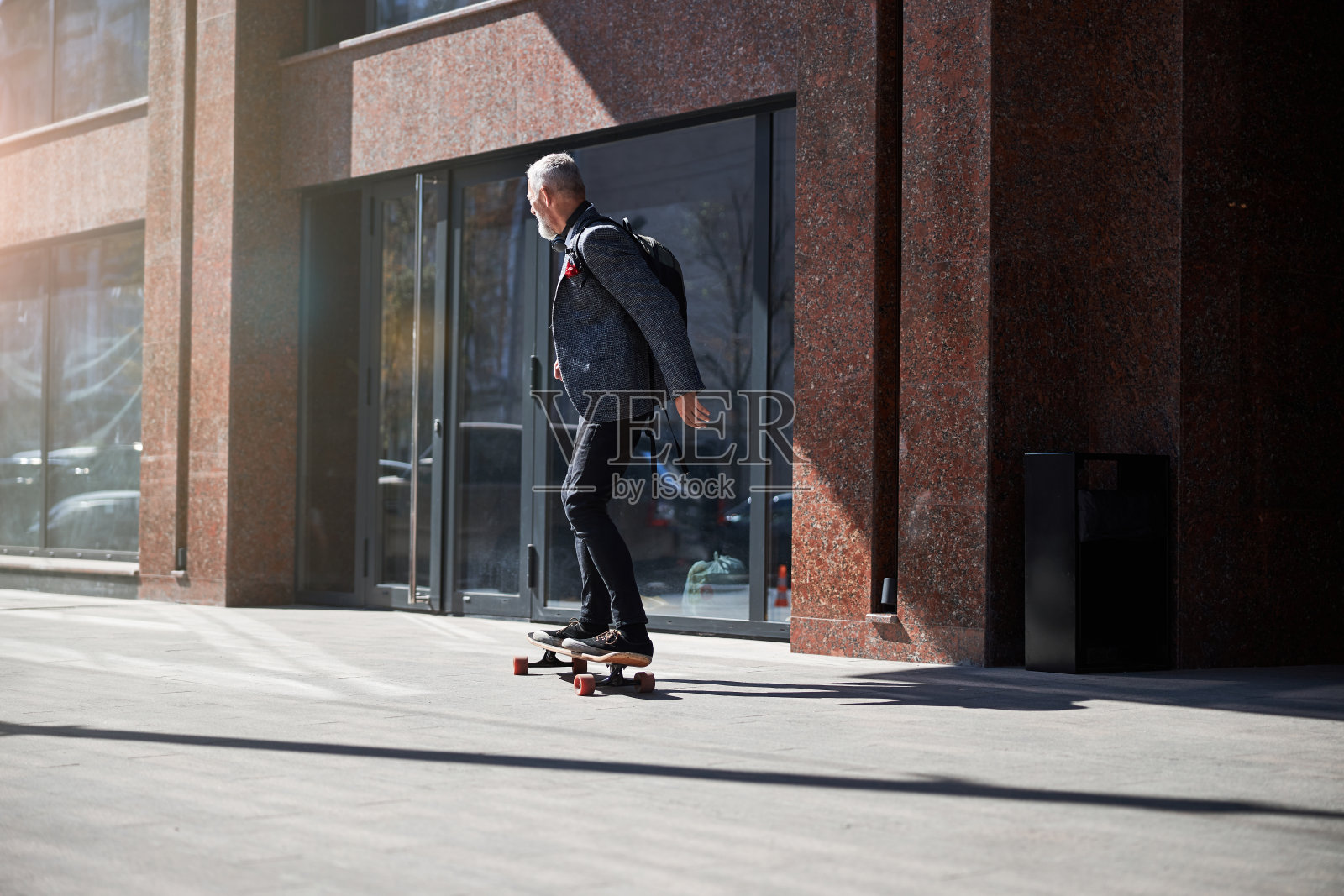 时尚的绅士骑着长板穿过街道照片摄影图片