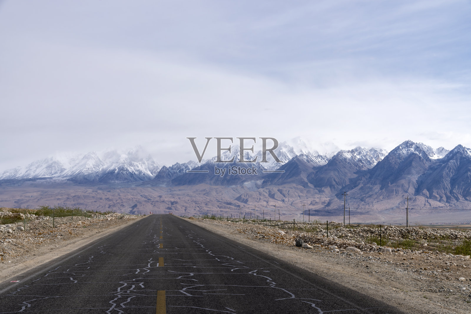 通往雪山的路，以蓝天白云为背景照片摄影图片