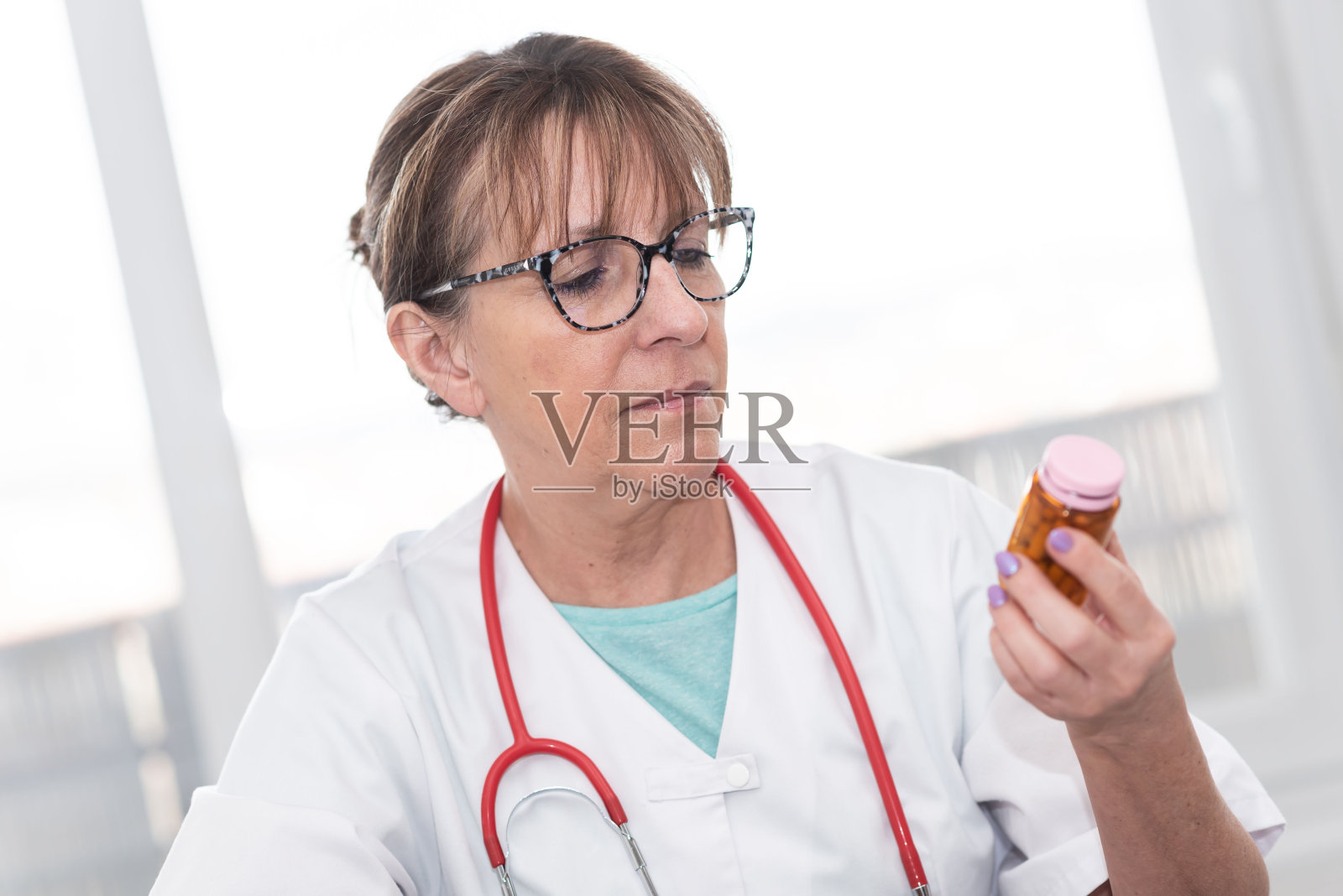 女医生正在看一瓶药照片摄影图片