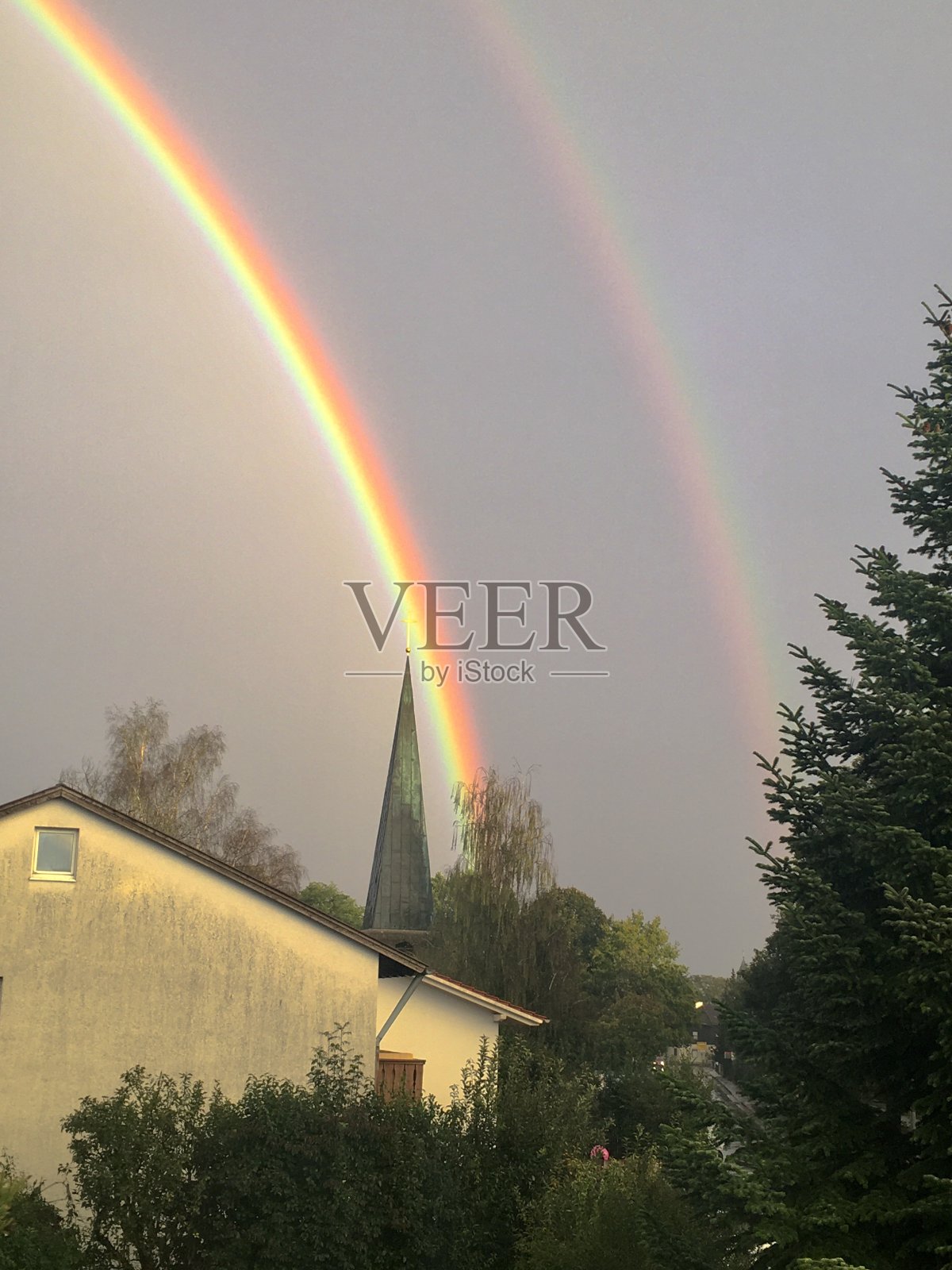 香草味的天空和教堂附近的双彩虹。照片摄影图片