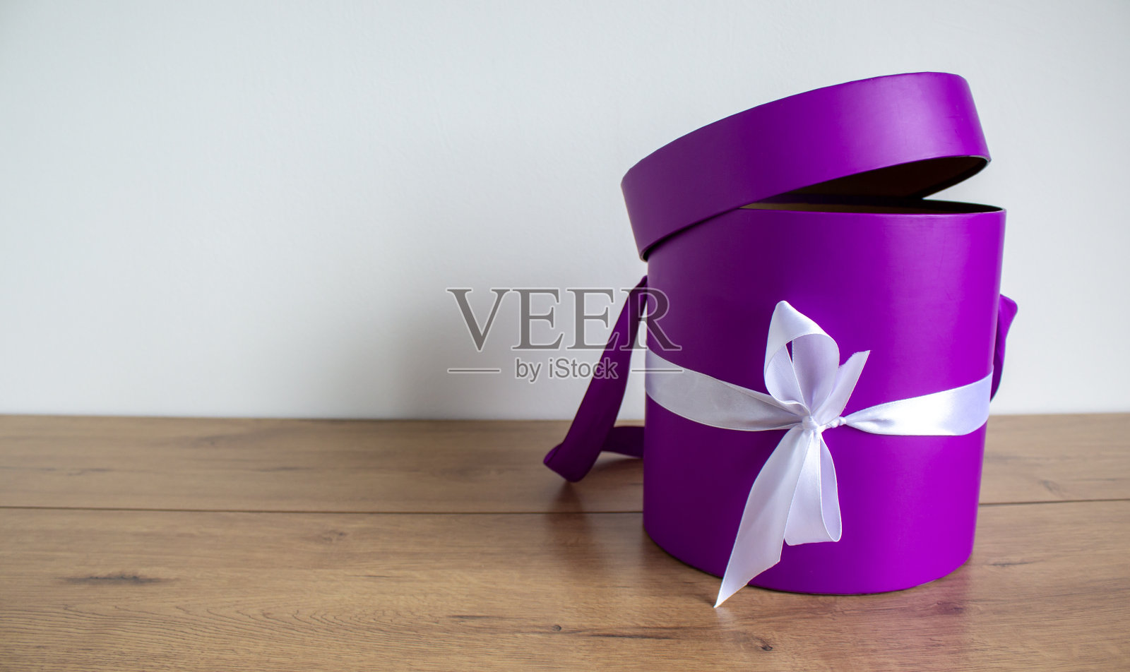 白色背景木桌上的圆形礼盒。副本的空间。照片摄影图片