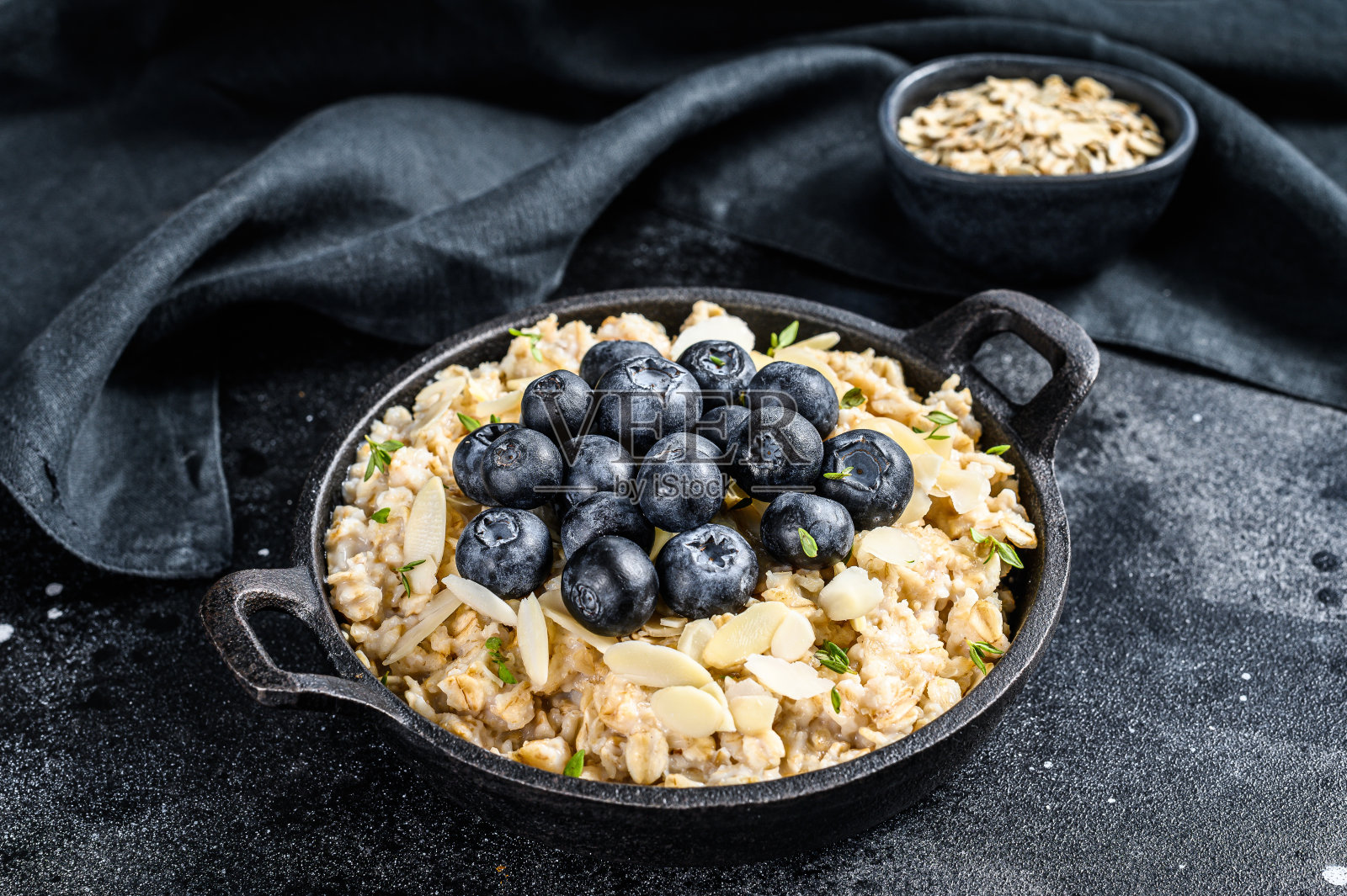 蓝莓杏仁燕麦粥。黑色背景。俯视图照片摄影图片