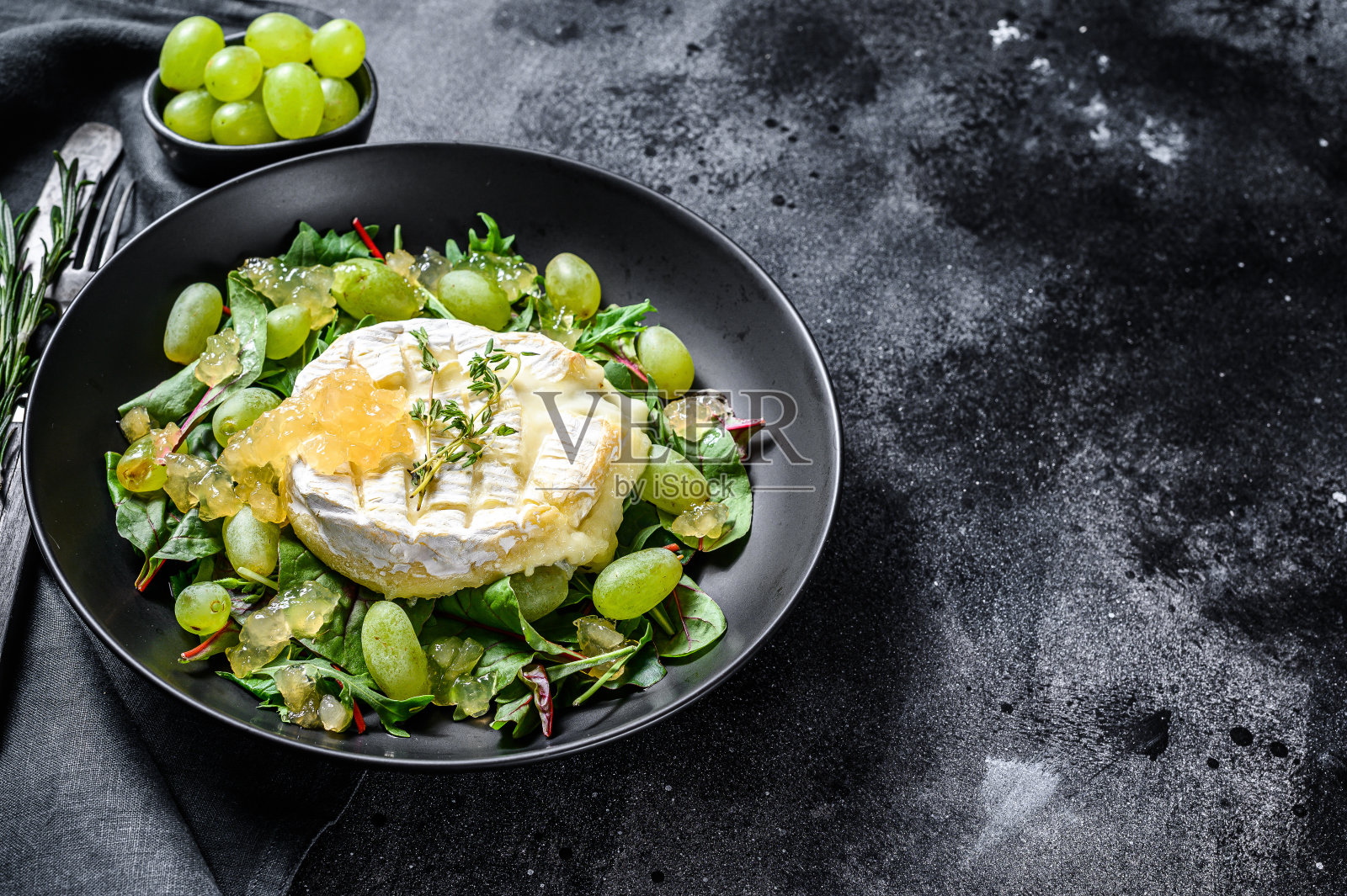 布里干酪，卡芒贝尔奶酪配葡萄，甜菜和芝麻菜。黑色背景。前视图。本空间照片摄影图片
