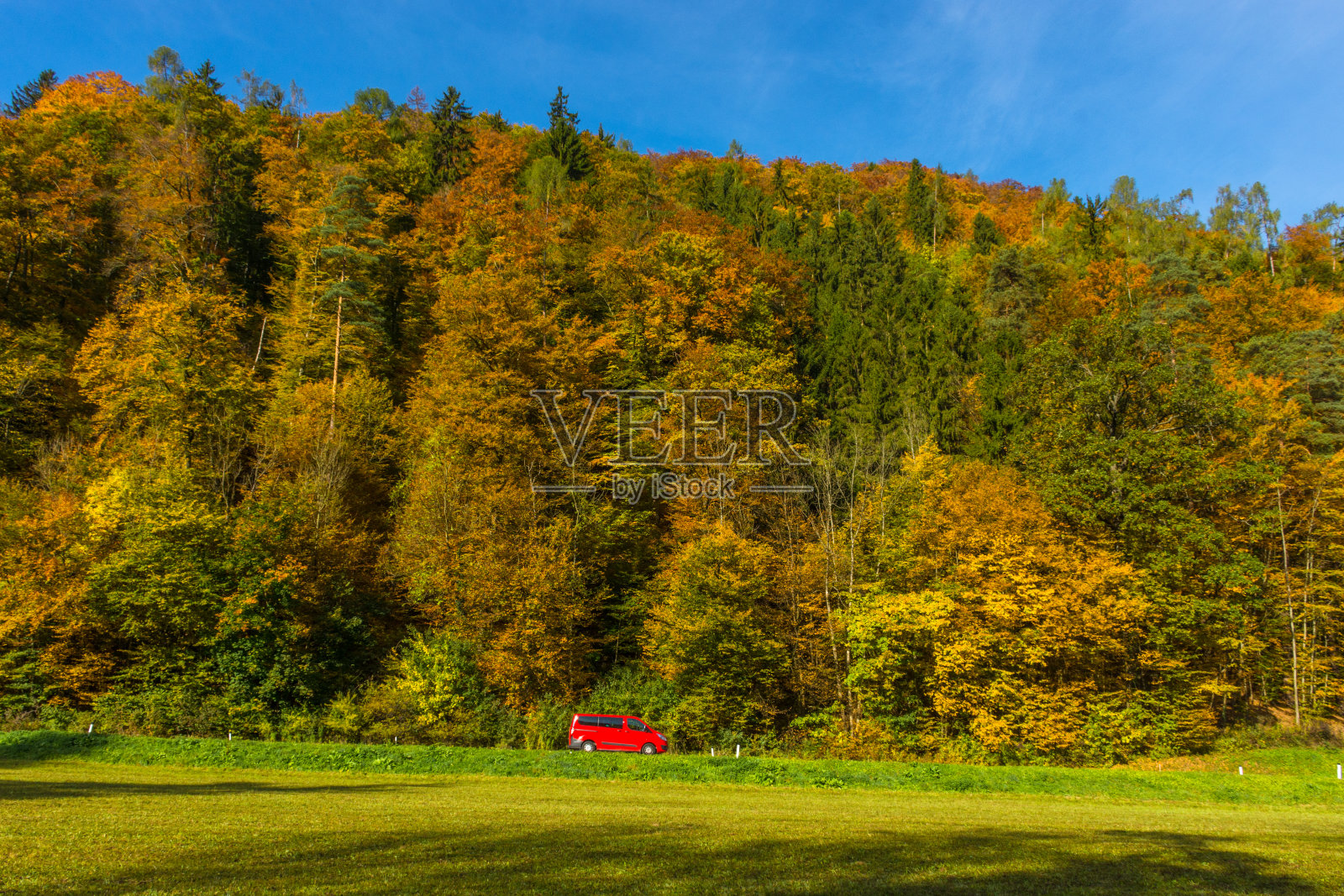 一辆红色小车穿过奥地利斯蒂里亚地区格拉茨附近美丽的秋景照片摄影图片