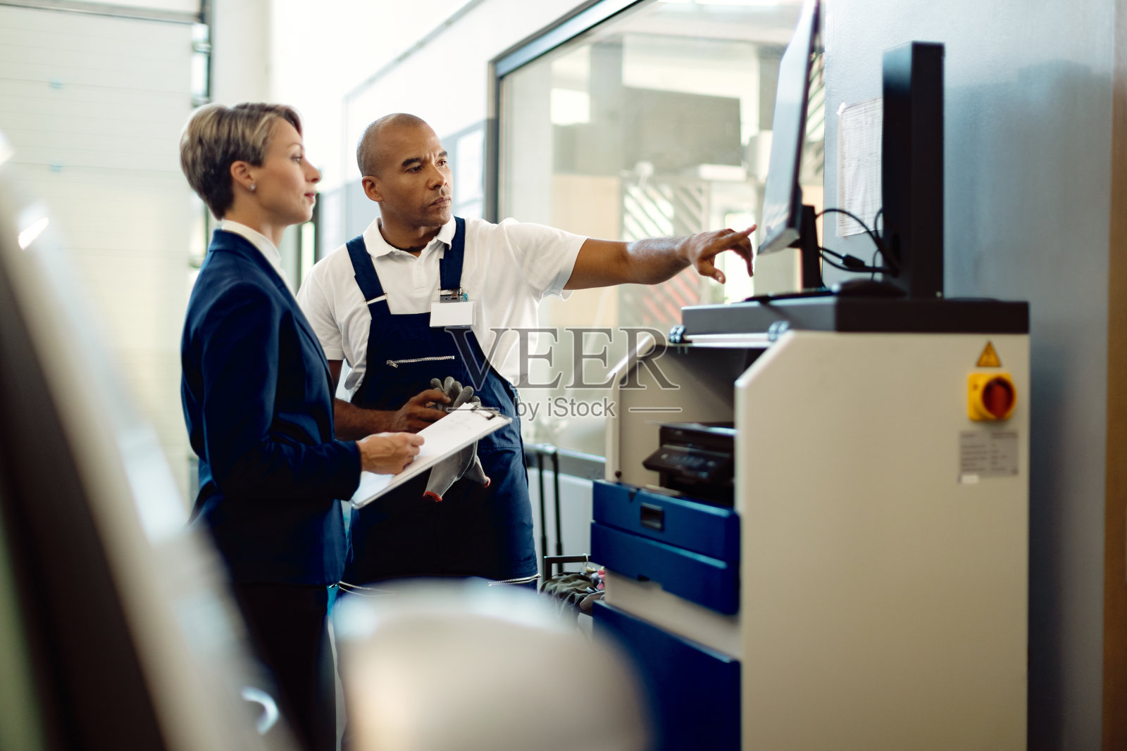 非裔美国汽车修理工和女商人在修理厂使用电脑。照片摄影图片