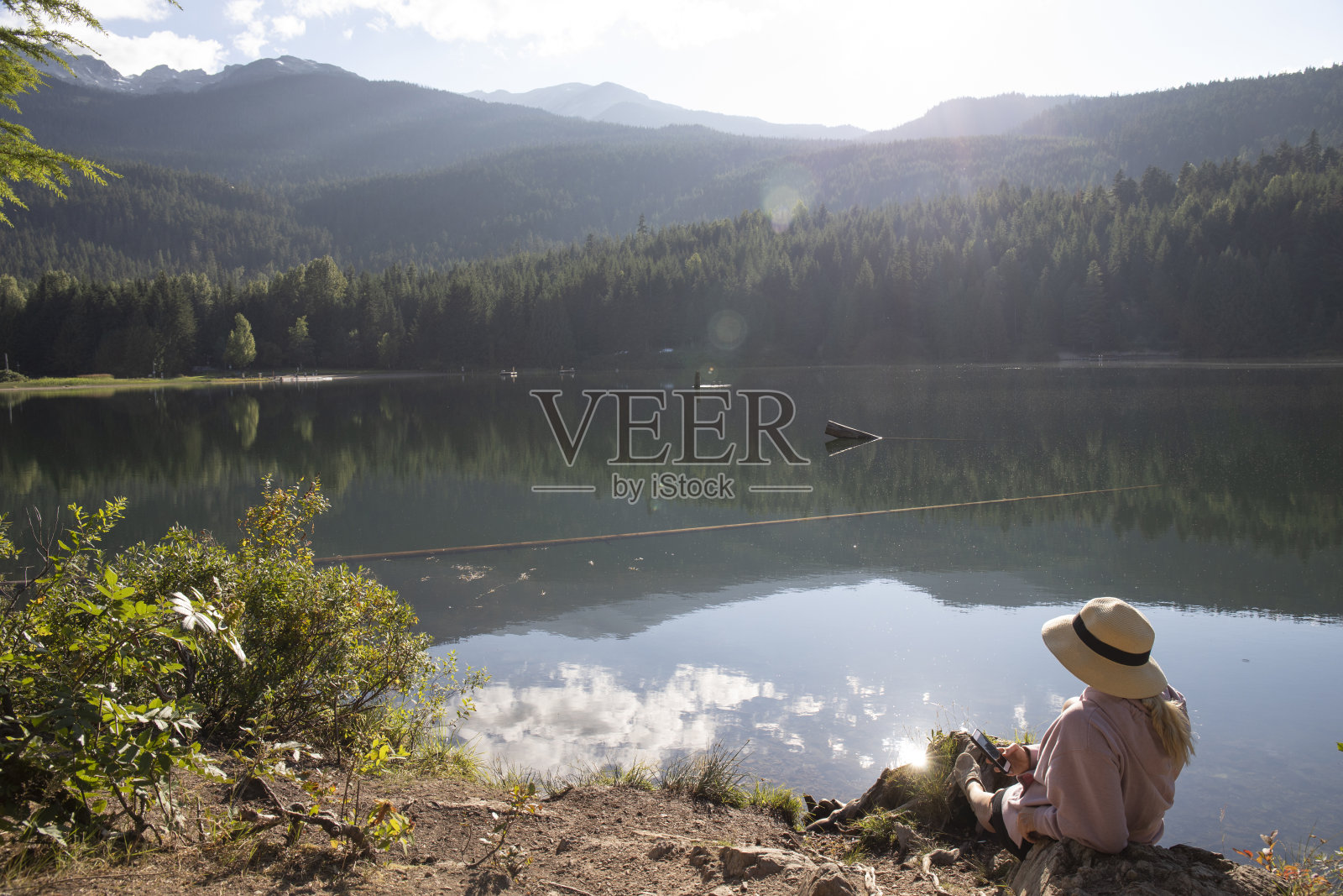 成熟的女人早晨在湖边放松照片摄影图片