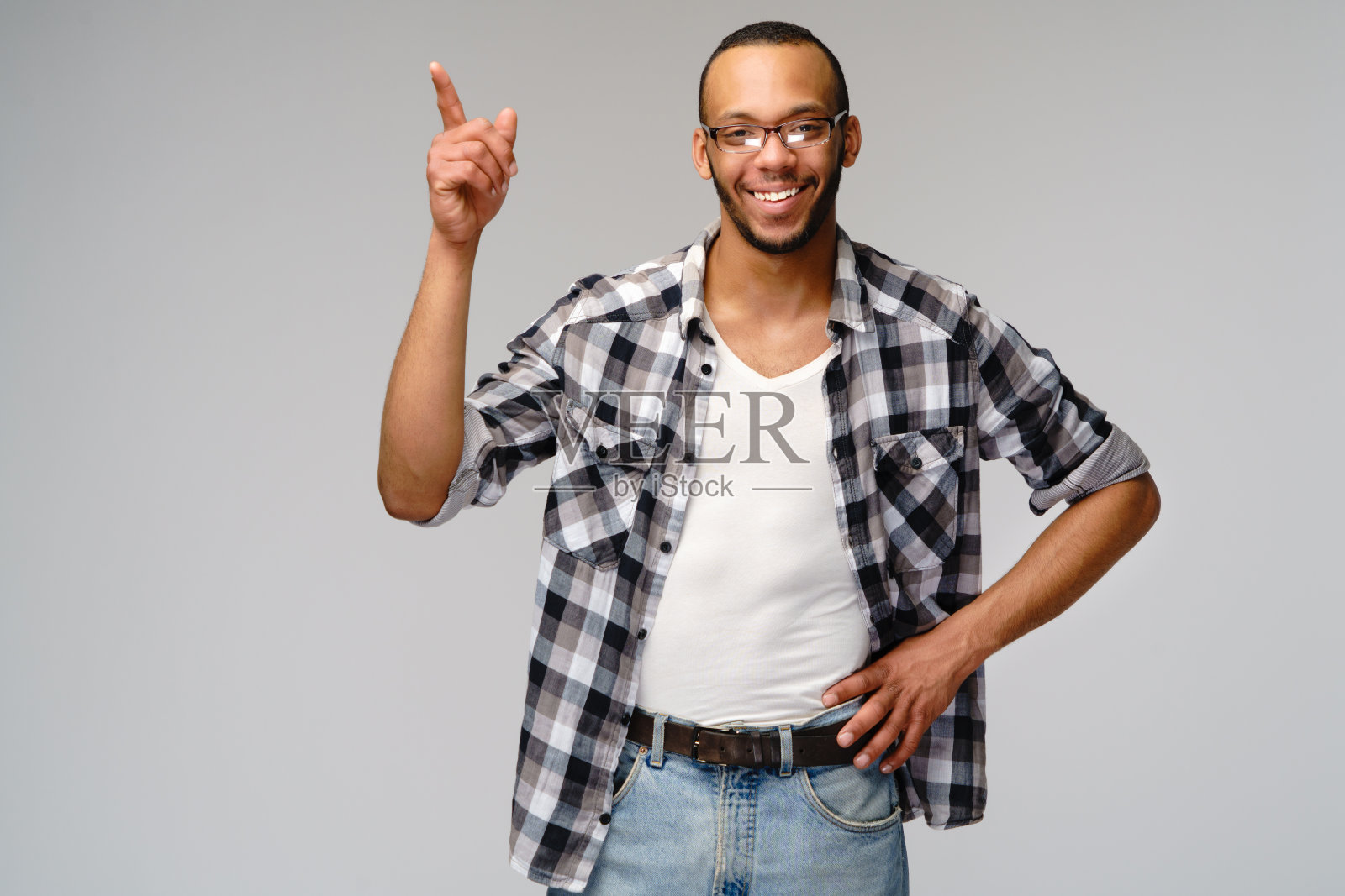 快乐友好的非洲裔美国年轻人穿着休闲衬衫指着复印空间照片摄影图片