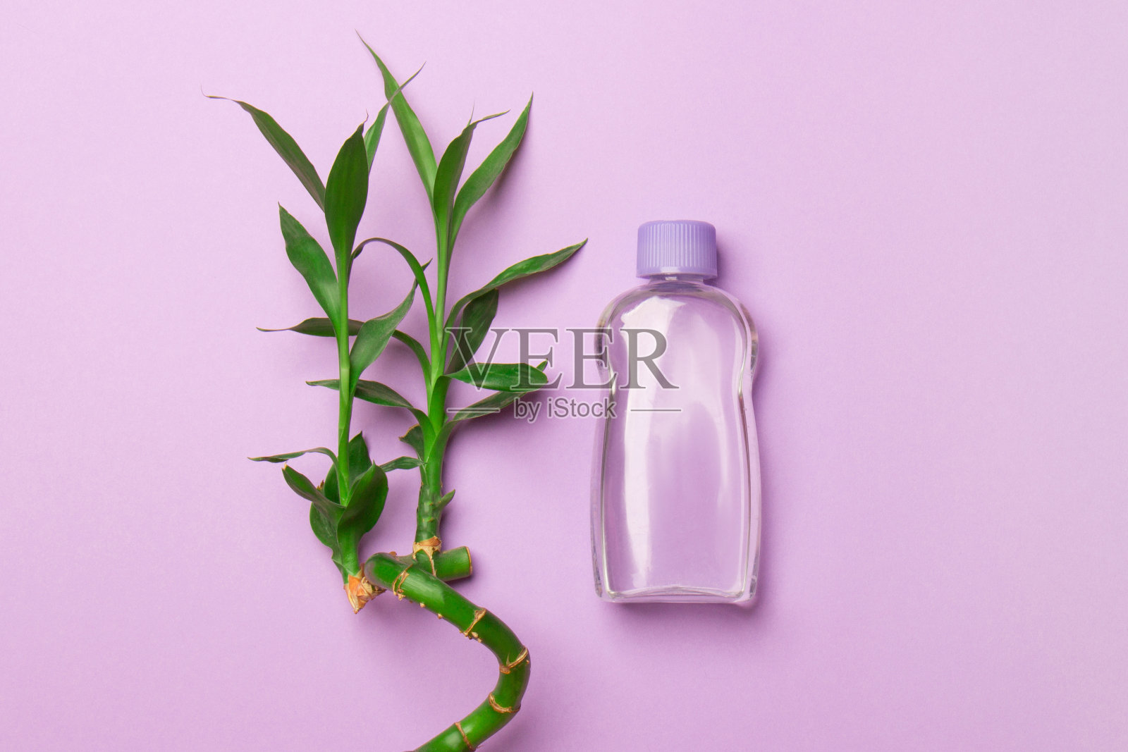 紫色的竹梗化妆瓶，紫色的背景照片摄影图片