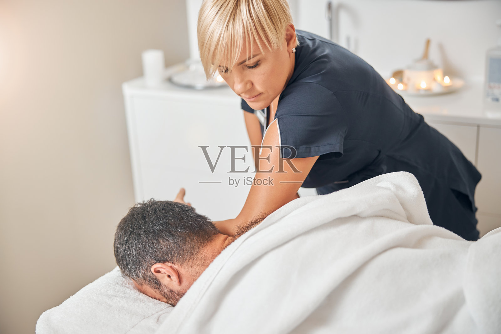 专业按摩师在水疗沙龙为男性客户按摩照片摄影图片