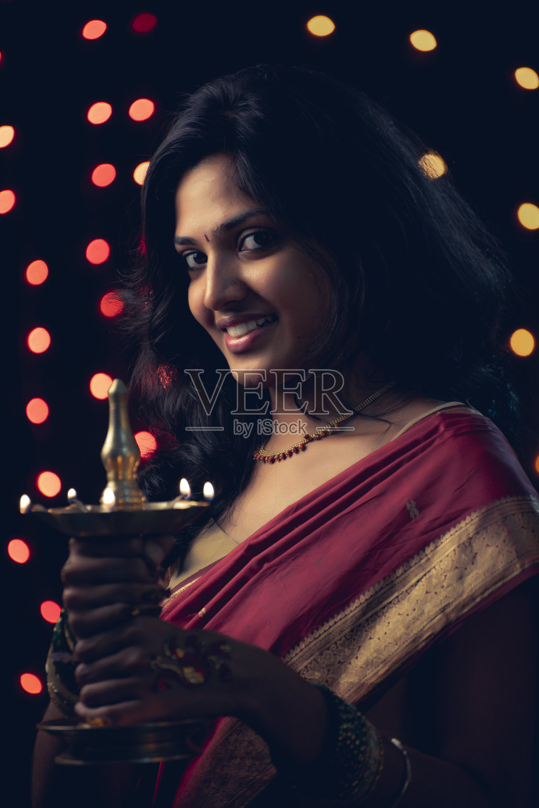 年轻的印度女孩拿着排灯节油灯照片摄影图片