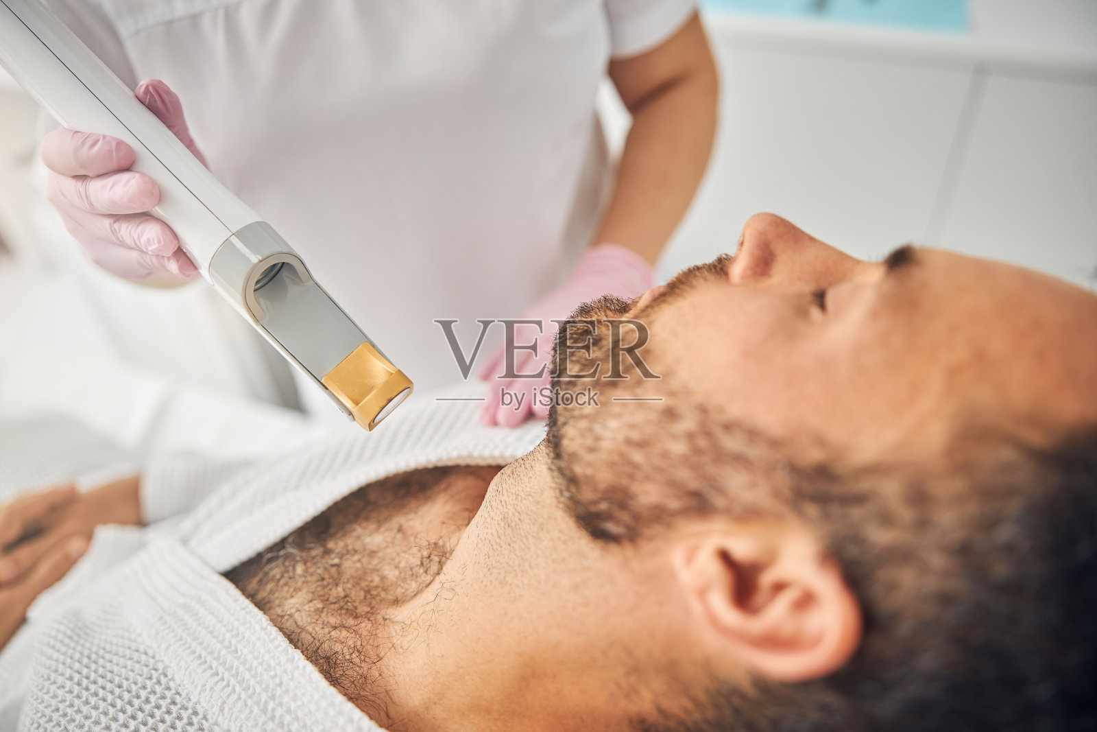 大胡子年轻人正在做激光脱毛手术照片摄影图片