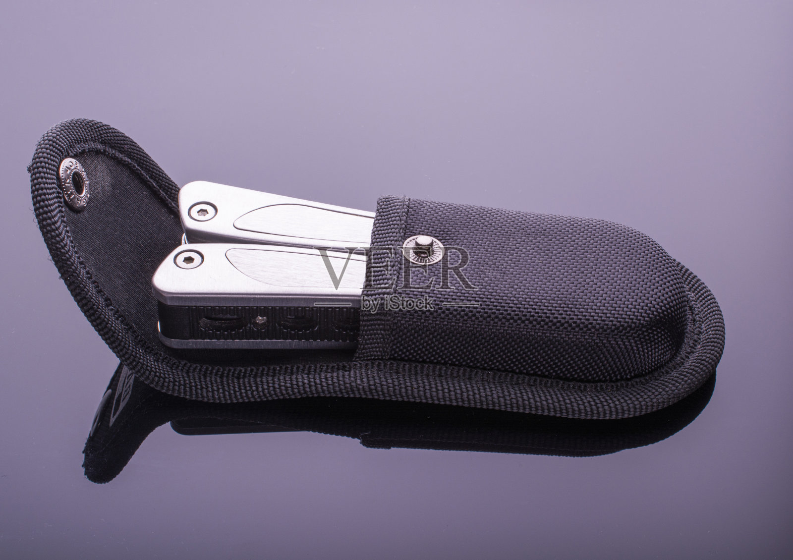 多功能刀在一个案例。由螺丝刀、钳子、刀片组成。概念刀适用于所有登山、修理场合。黑暗的背景。黑暗的背景。照片摄影图片