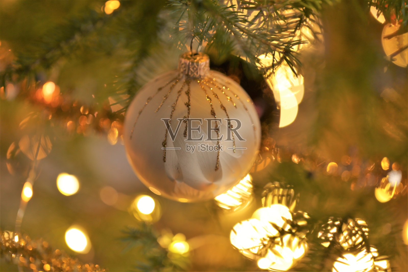 圣诞节和新年的背景。金色的装饰球和闪闪发光的花环装饰在圣诞树上。冬季节日背景在温暖的颜色。带花环的寒假壁纸。照片摄影图片