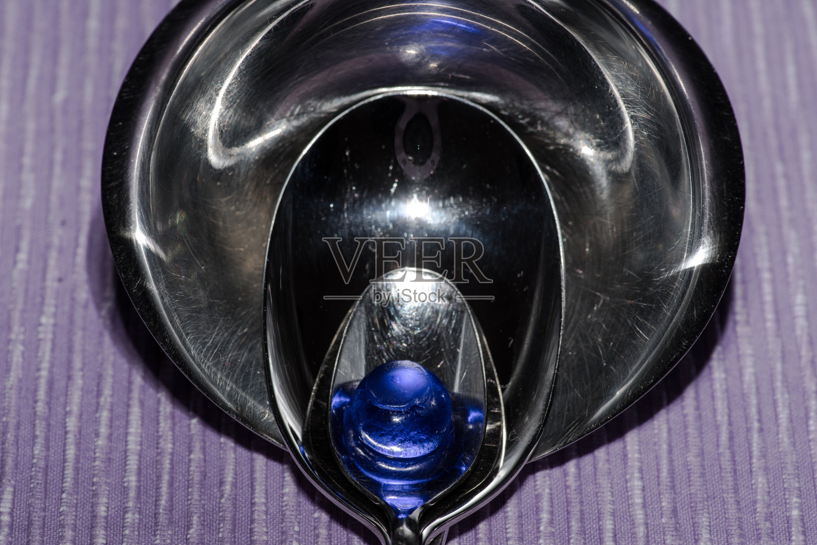 3个不同的连锁勺子和蓝色玻璃球照片摄影图片