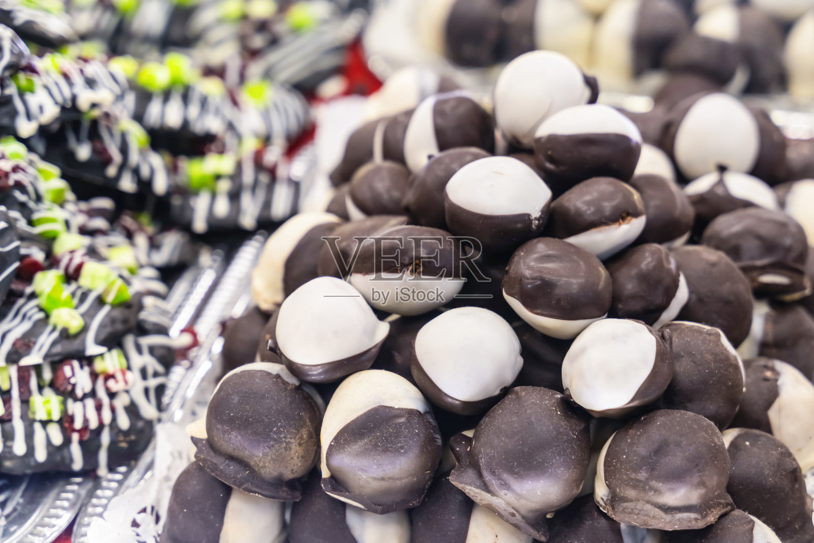 杏仁糖糖果覆盖着巧克力涂层黑色和白色的模糊的甜点背景特写照片摄影图片