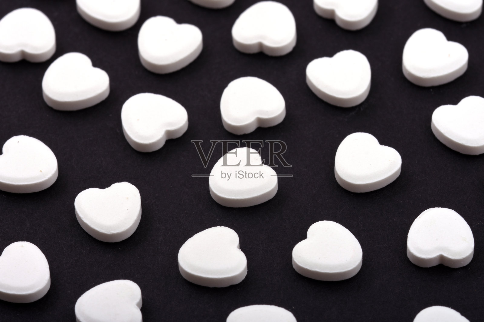 黑色背景上的心形药丸。帮助人们的药物。照片摄影图片