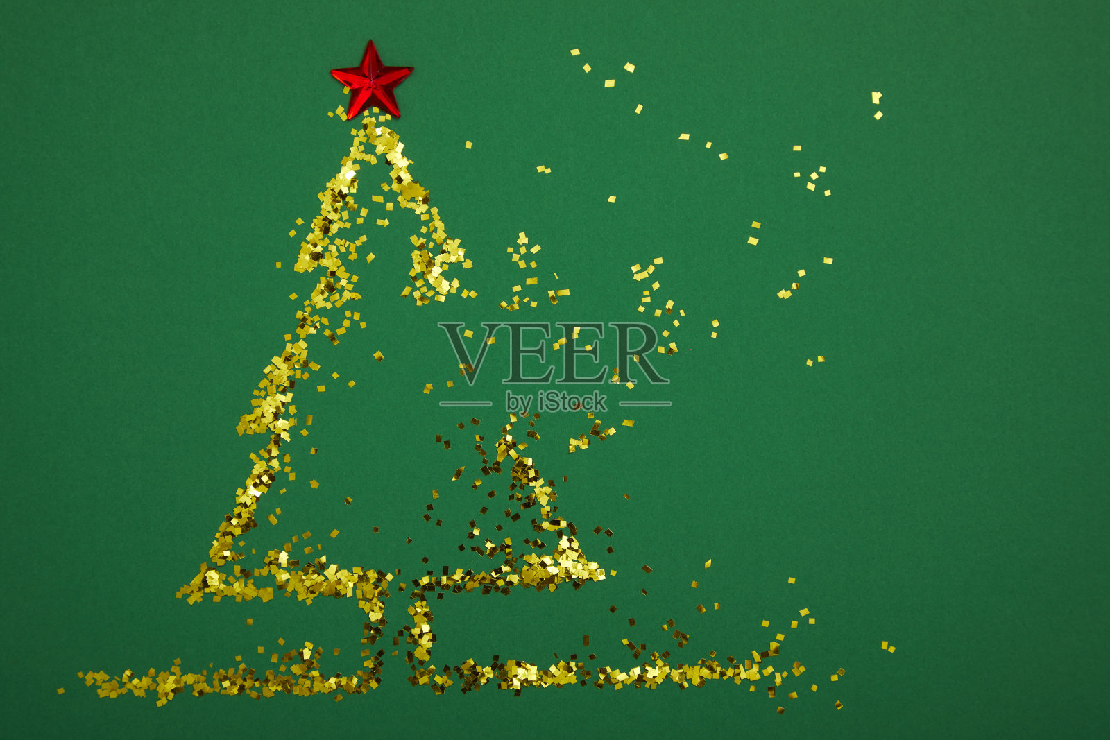 圣诞树由金色的亮片和红色的星星在绿色的背景。照片摄影图片