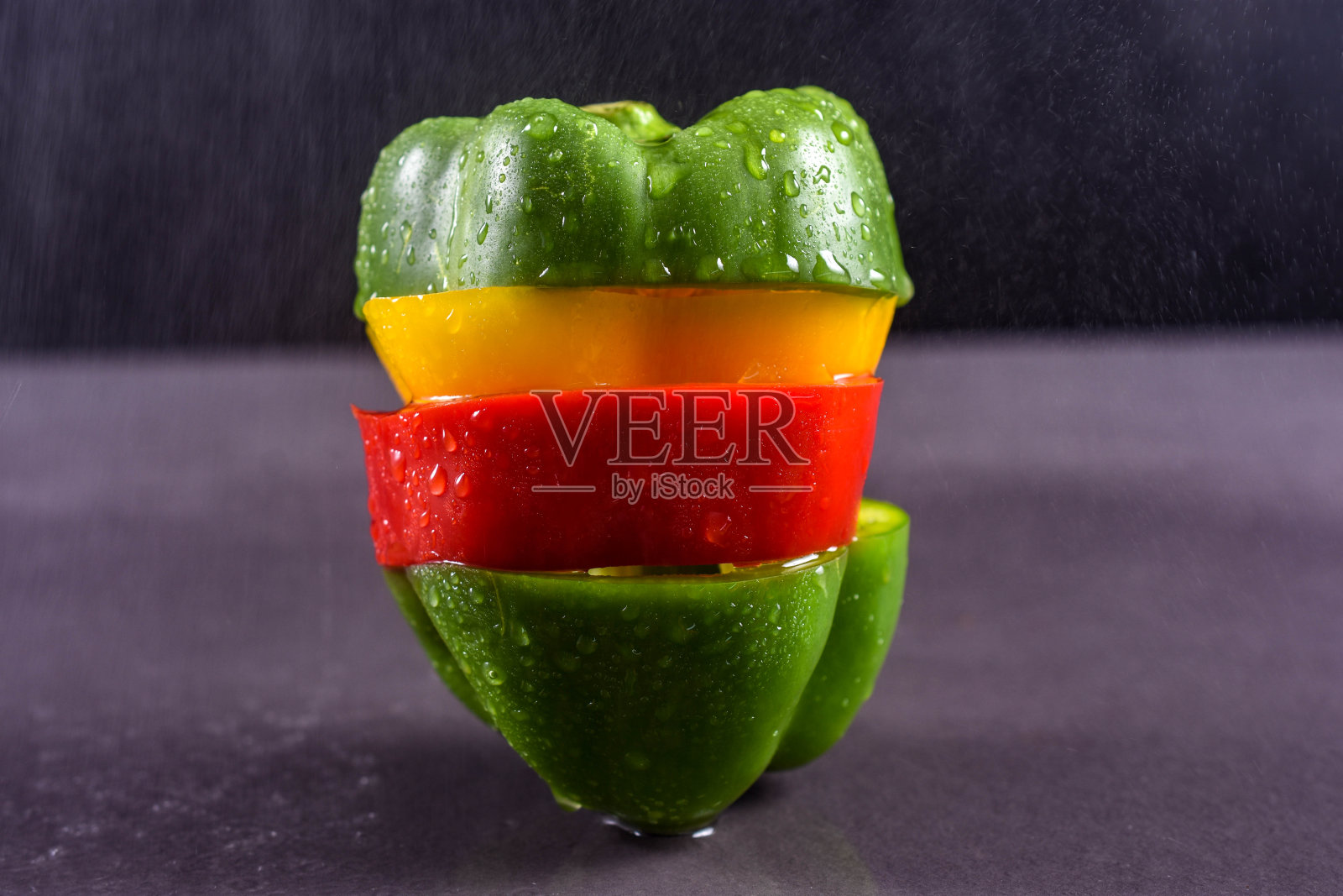 七彩辣椒切好叠好。在摄影棚里以黑色为背景近距离拍摄照片摄影图片