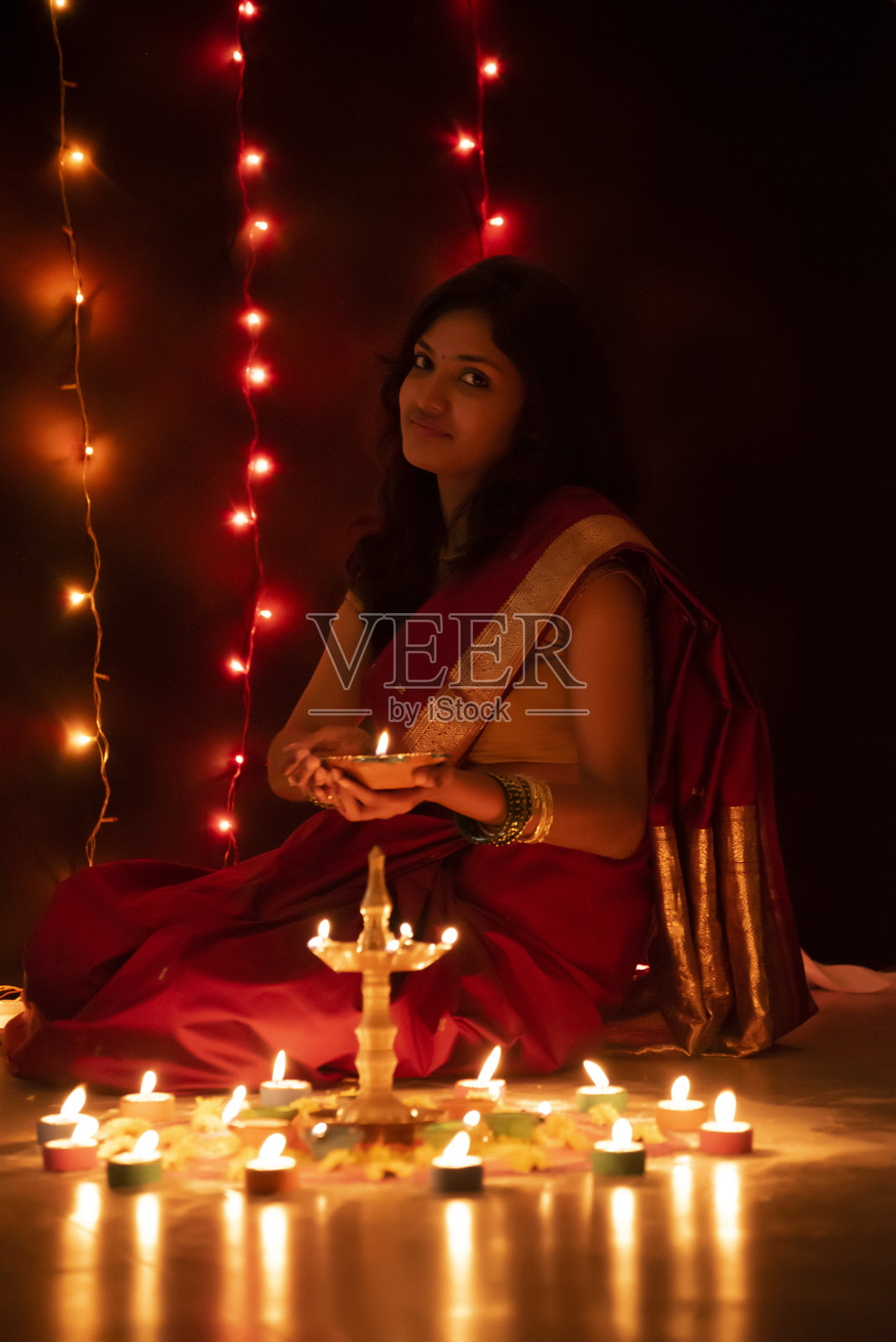 年轻的印度女孩拿着排灯节油灯照片摄影图片