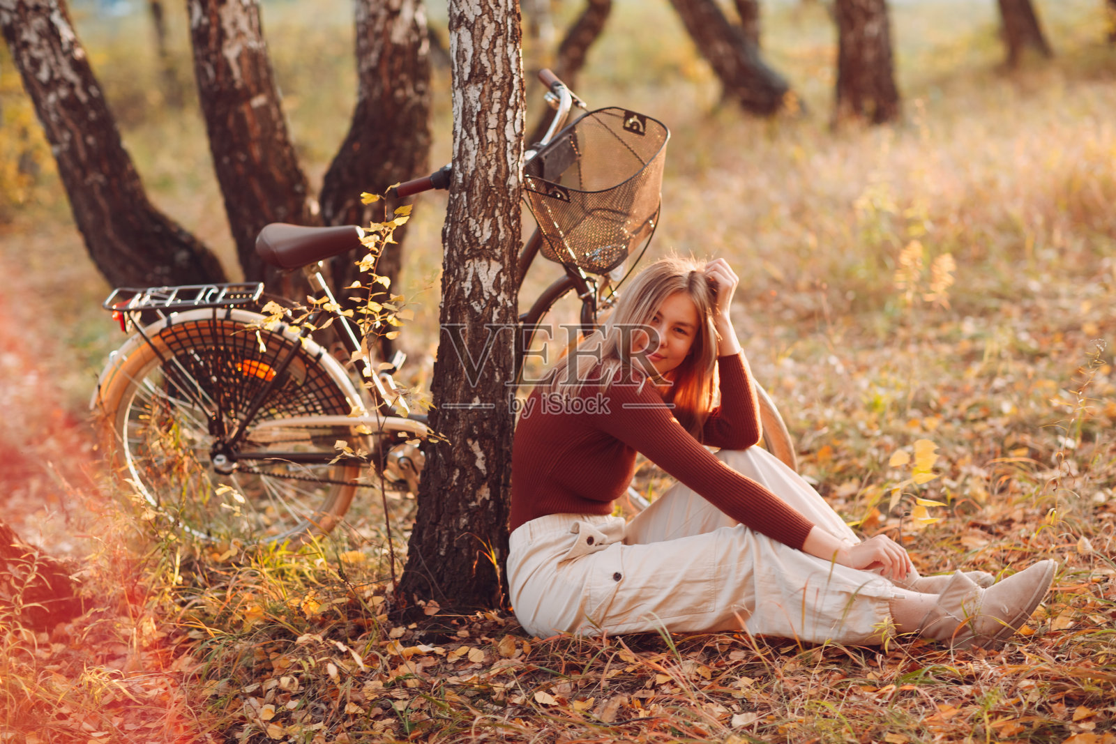 快乐活跃的年轻女子坐在复古自行车在秋天公园日落照片摄影图片