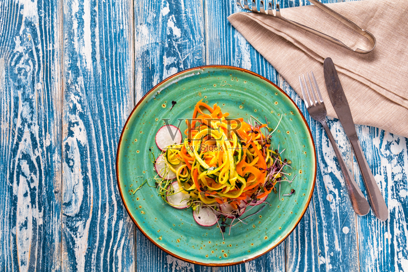 胡萝卜和西葫芦做成的蔬菜意大利面。盛在陶瓷盘子里。照片摄影图片