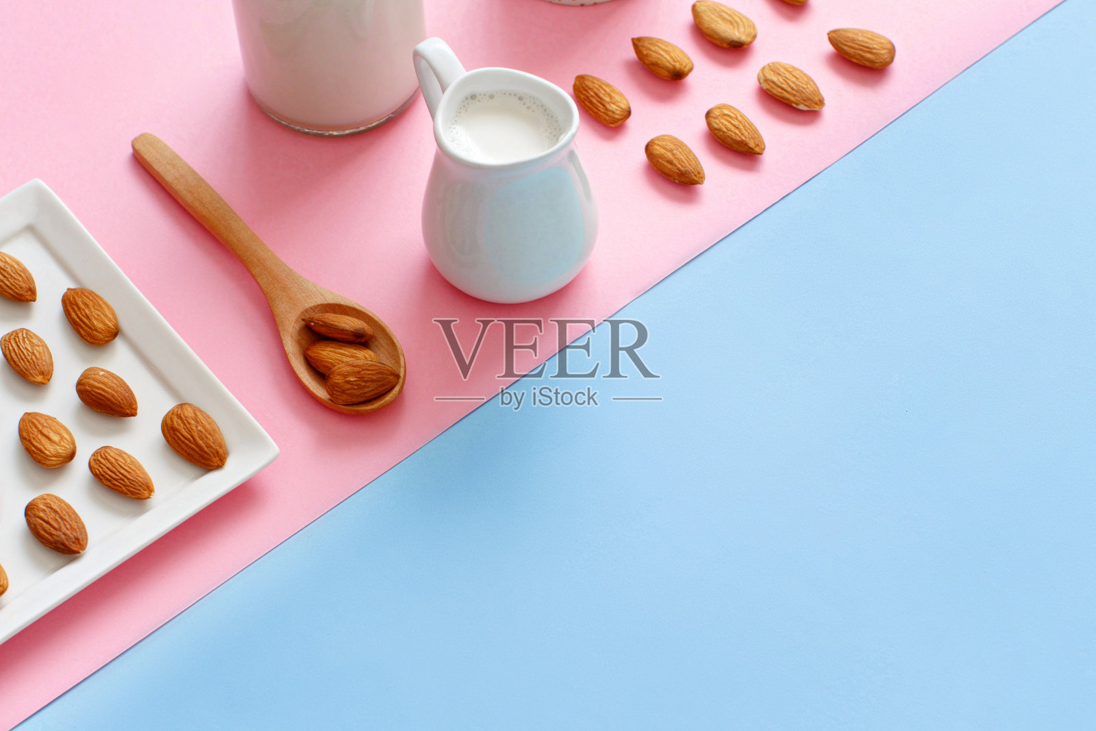 粉色和蓝色背景上的纯杏仁牛奶照片摄影图片