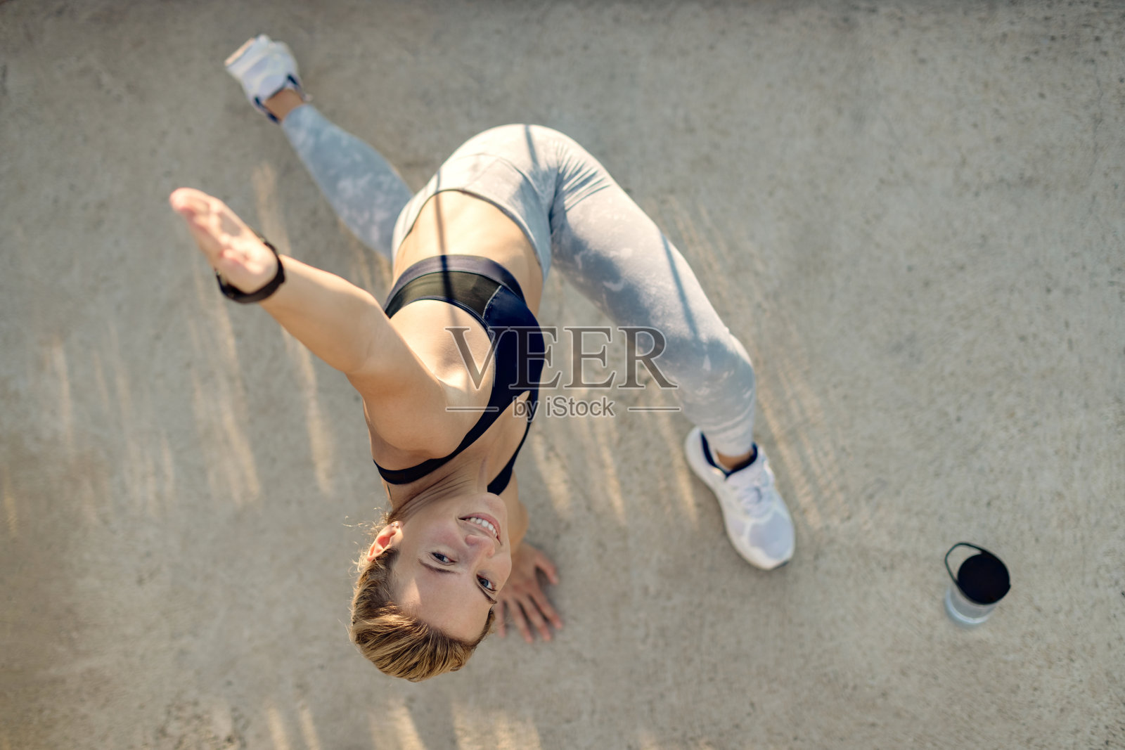 上图是快乐的女运动员在户外做放松运动。照片摄影图片