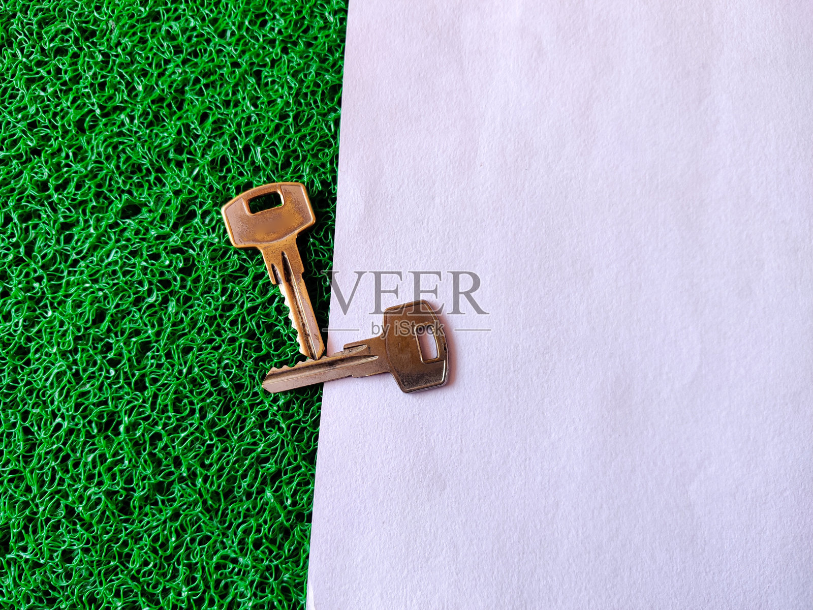 房子的钥匙隔离在白色和绿色的背景。有选择性的重点照片摄影图片
