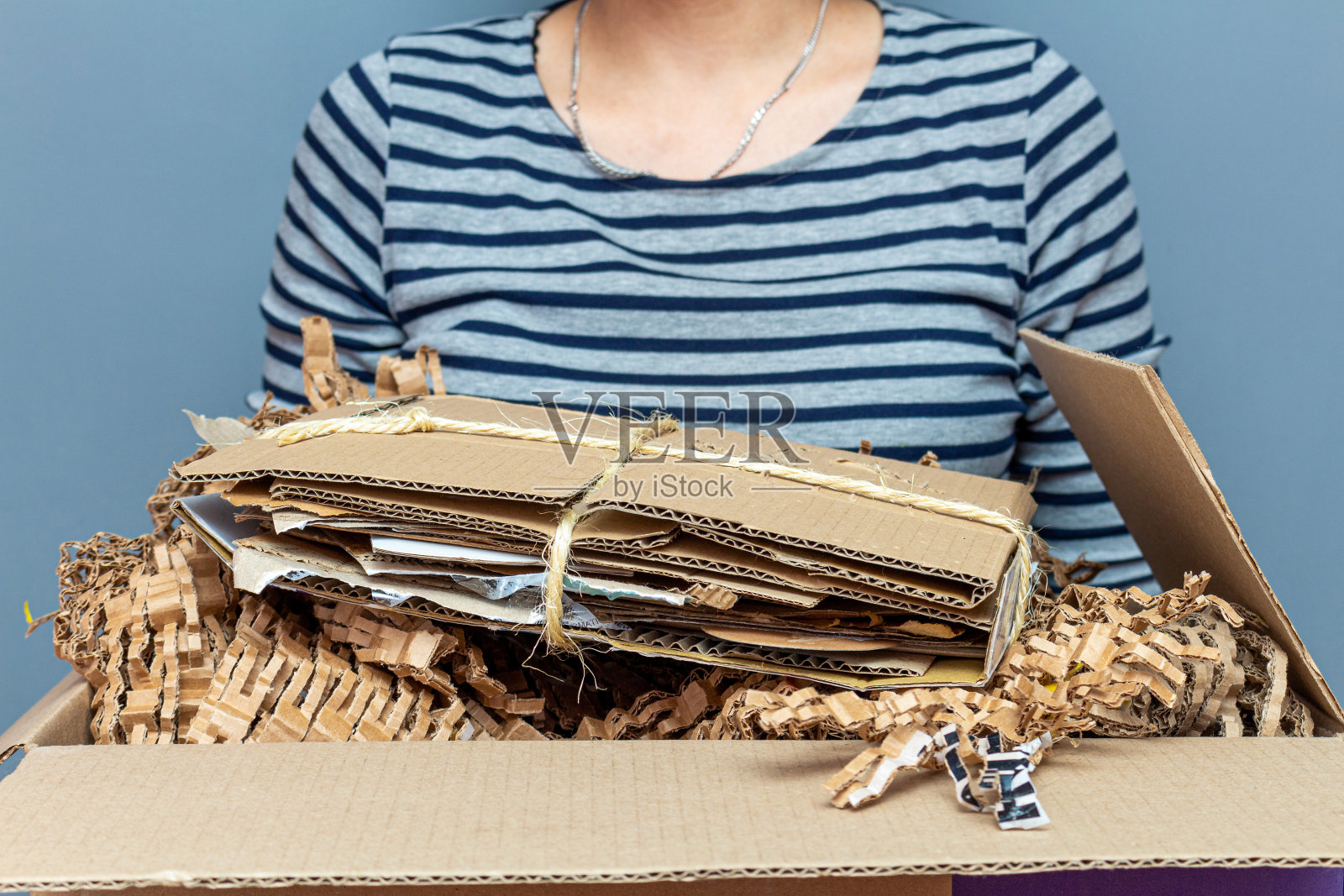 女孩拿着纸板箱装着纸，卡通用过的废物，垃圾供回收利用照片摄影图片