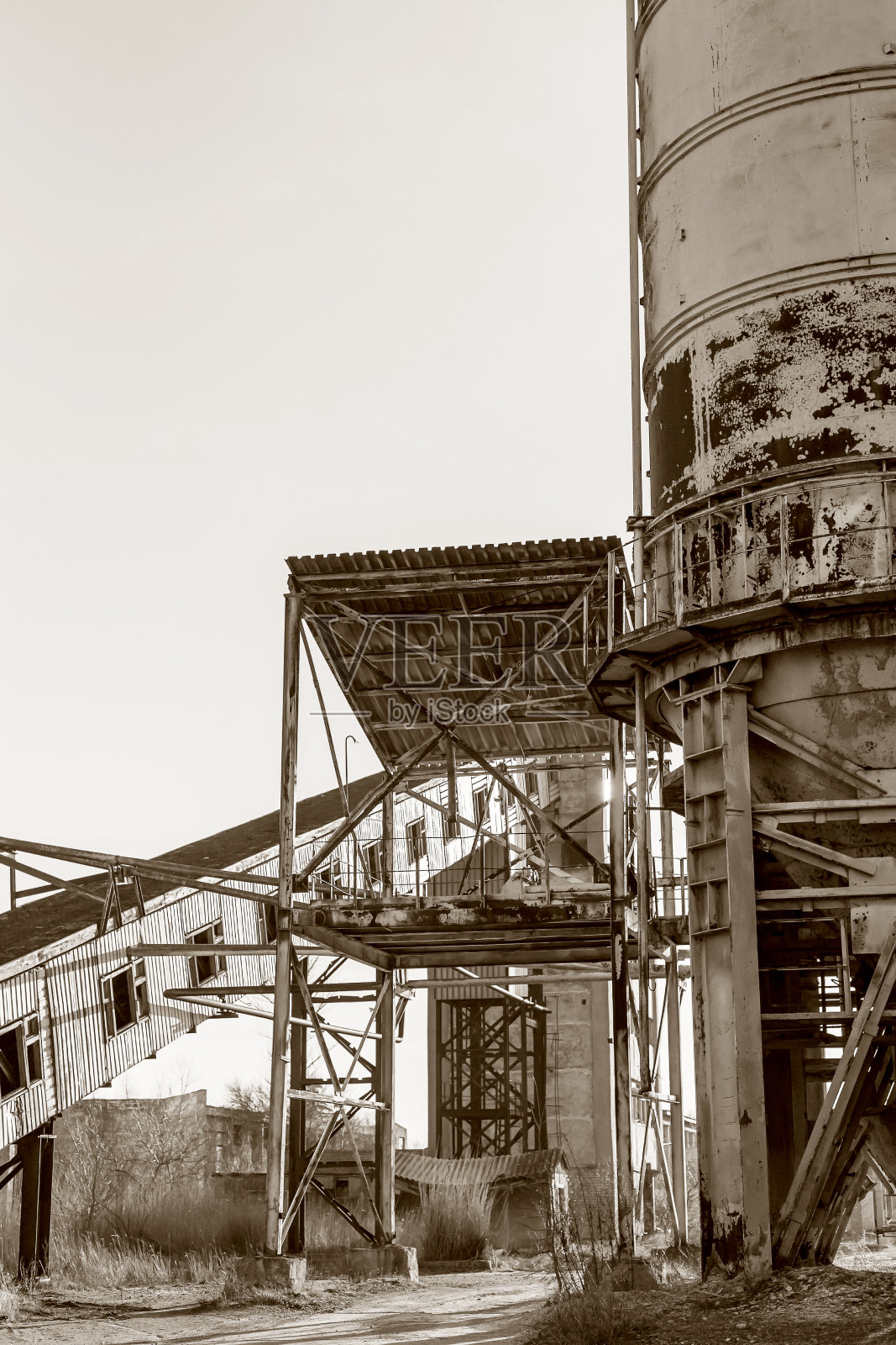 旧的，废弃的混凝土工厂有生锈的铁罐和金属结构。危机爆发，经济下滑，生产能力停止导致崩溃。全球灾难。老照片的效果照片摄影图片