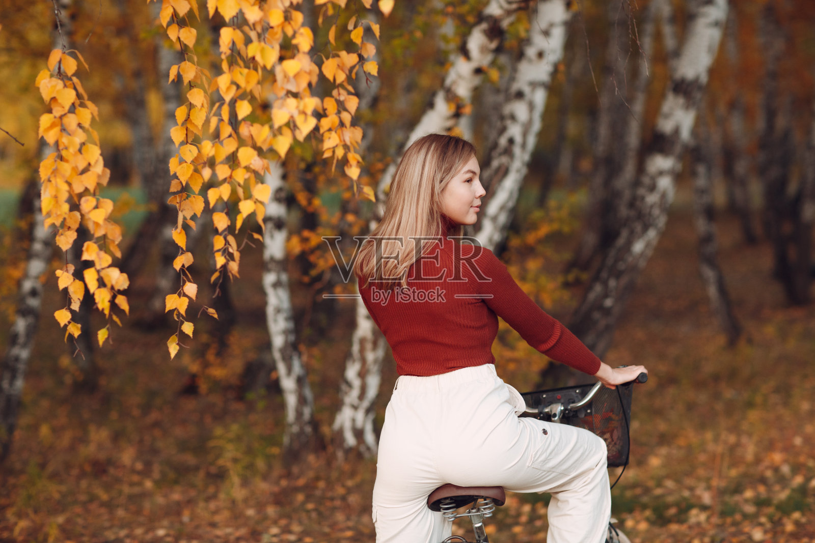 快乐活跃的年轻女子在秋天的公园骑自行车照片摄影图片