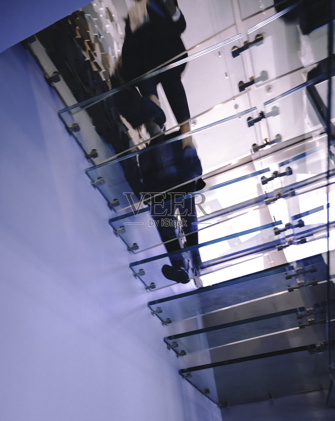 商业人士走在现代的玻璃楼梯上照片摄影图片