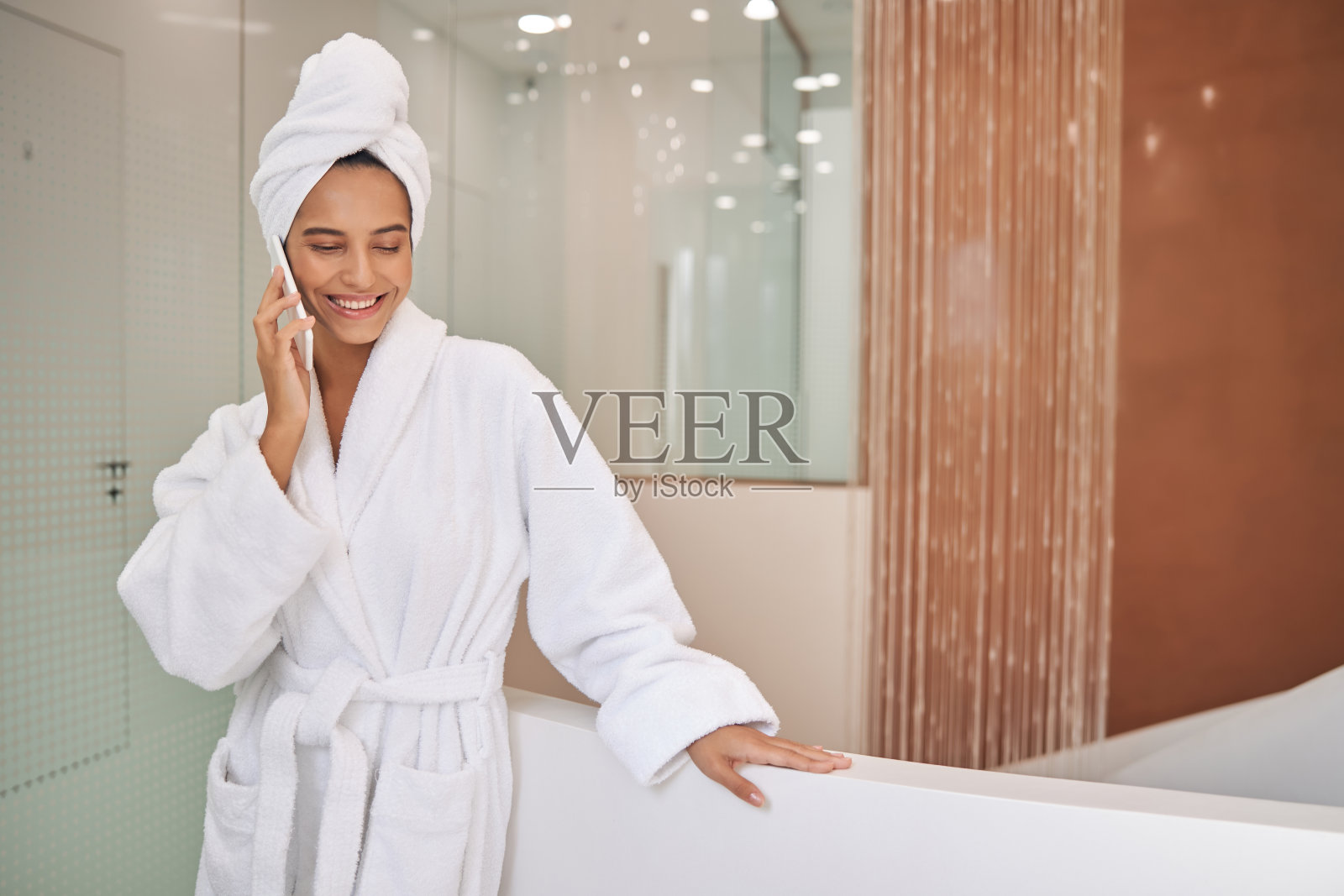 淋浴后聊手机的快乐年轻女人照片摄影图片