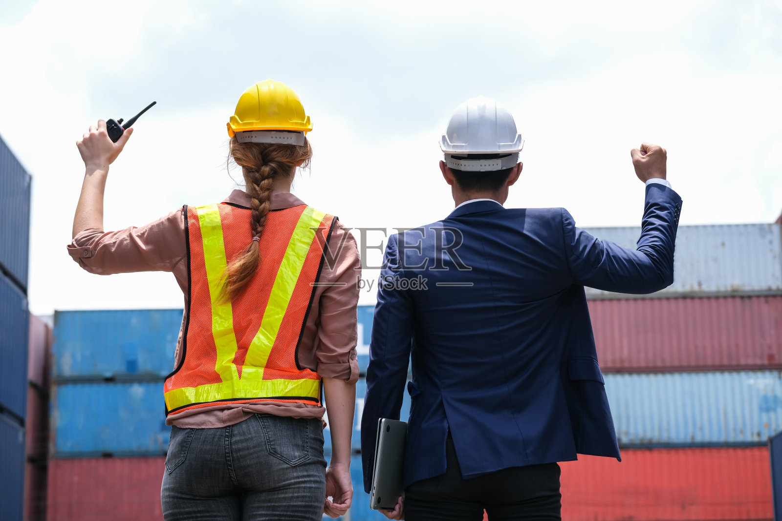 集装箱货运区，工程师工人拿着对讲机和老板拿着笔记本电脑举起手。成功的工作。进出口物流运输理念照片摄影图片
