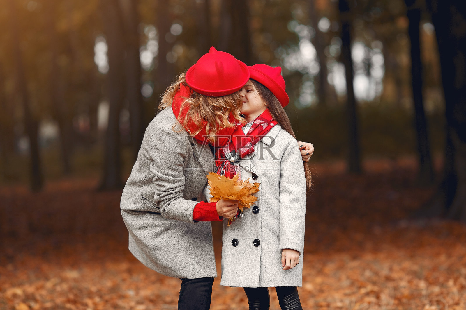 可爱和时尚的家庭在秋天的公园照片摄影图片