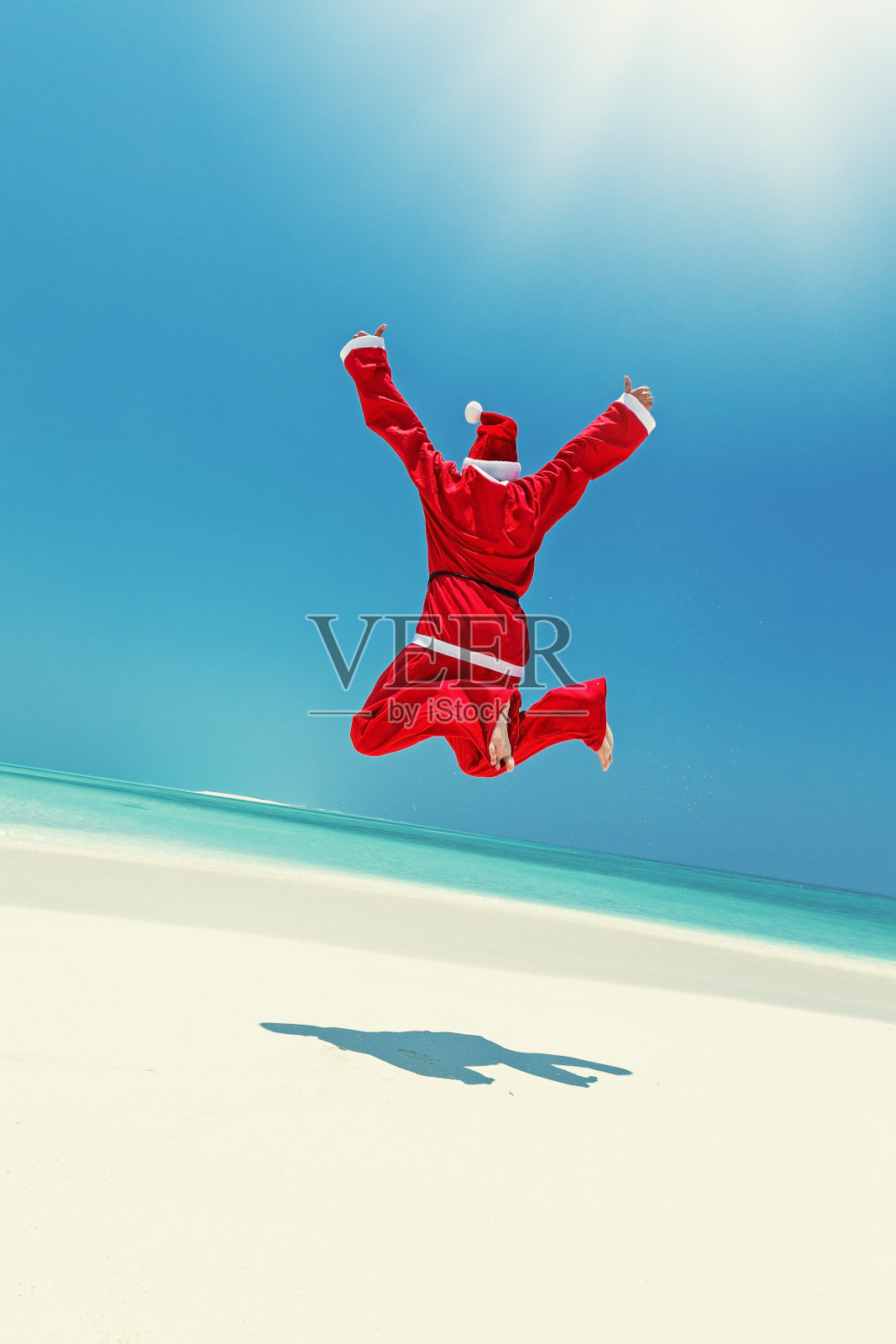圣诞老人在海滩上跳跃照片摄影图片