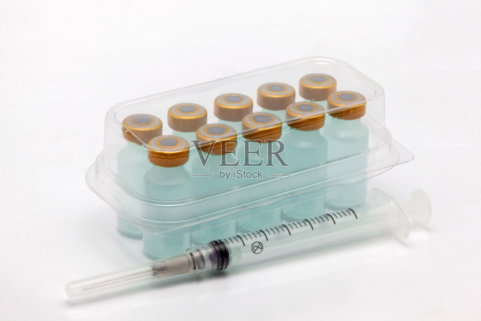 十个疫苗瓶装在封闭的半透明塑料盒里和一个注射器照片摄影图片