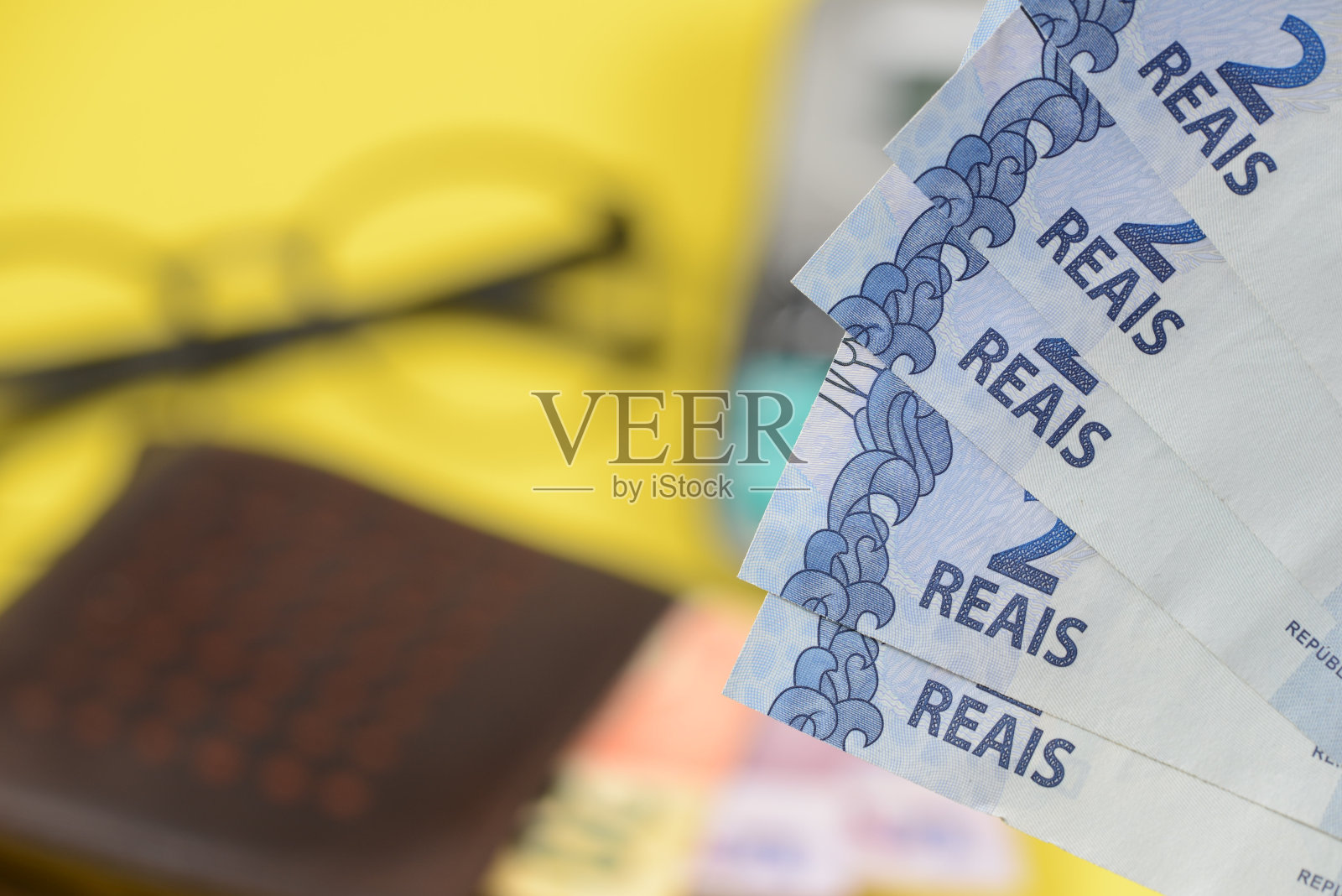 模糊背景下的钱从钱包里出来。照片摄影图片