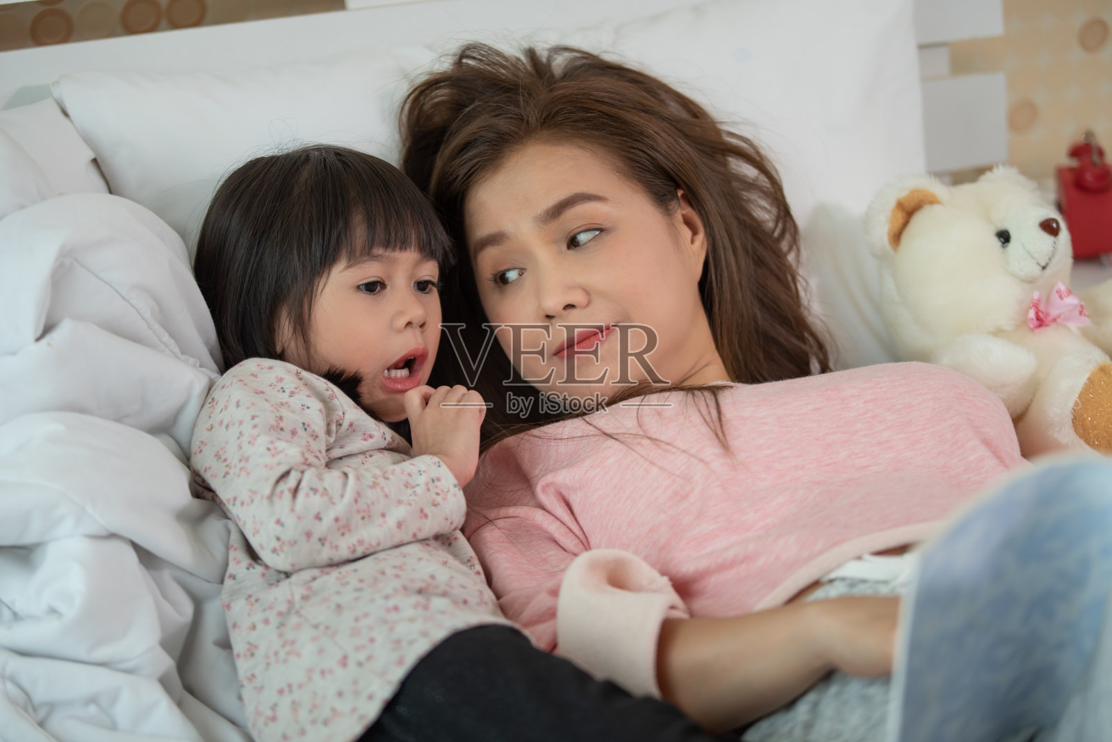 幸福家庭母女在卧室床上看书，亚洲家庭爱的理念照片摄影图片