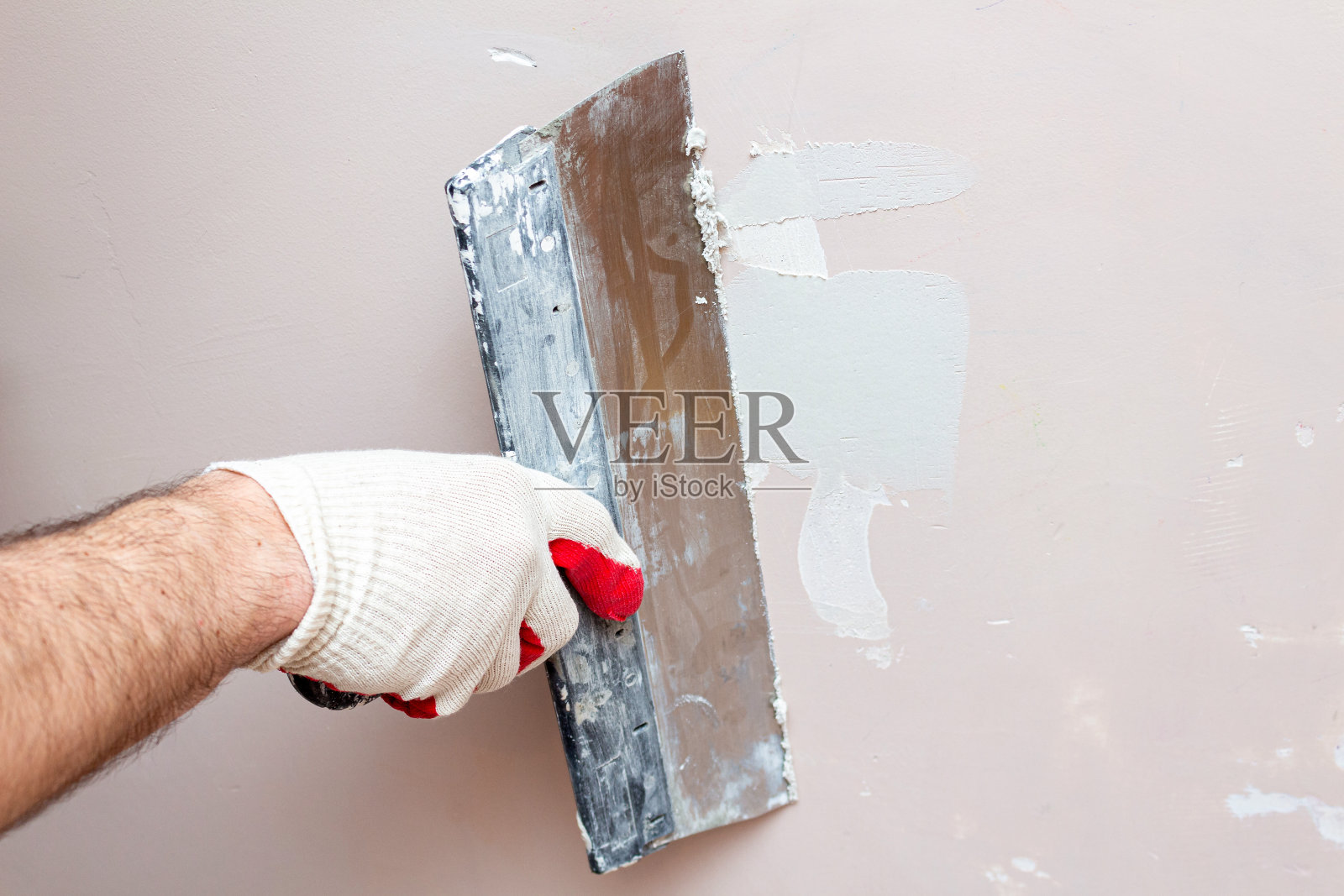 用抹刀涂抹石膏，密封裂缝。墙修复受损。照片摄影图片