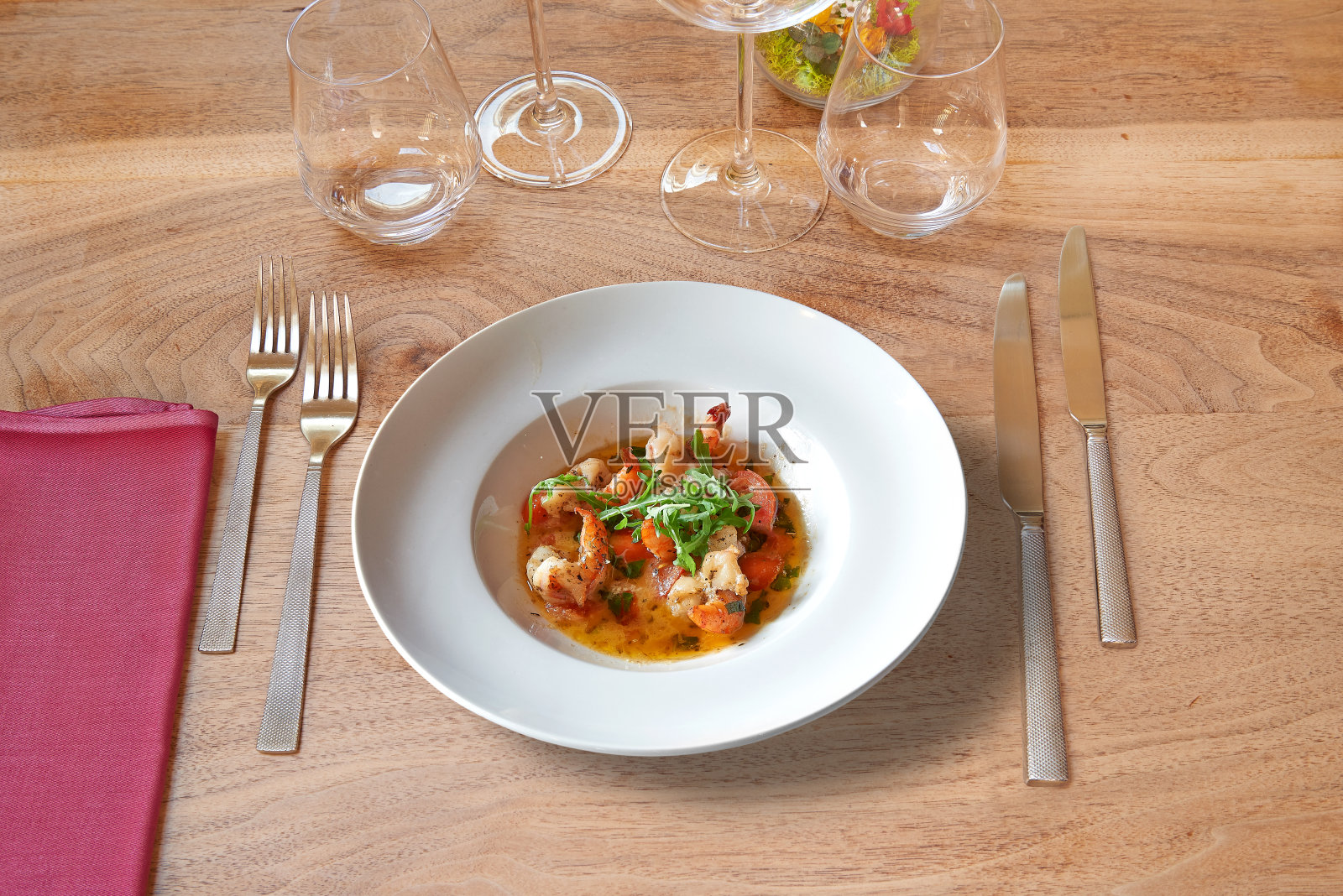 木制的桌子，白色的圆盘子和蒜蓉虾。照片摄影图片