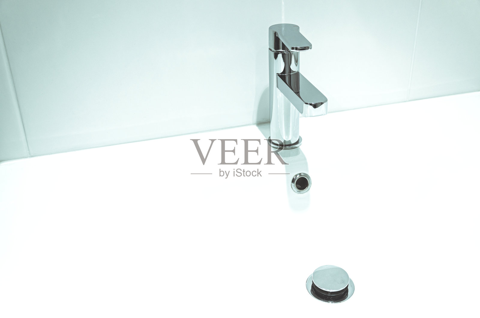 白色墙壁的浴室盥洗架上的新水龙头。修复照片摄影图片