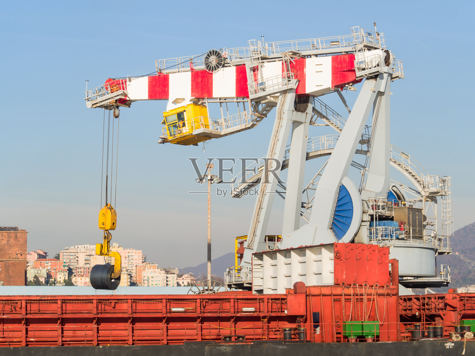 意大利热那亚:在货船上装载轧制钢板卷的大型港口起重机照片摄影图片