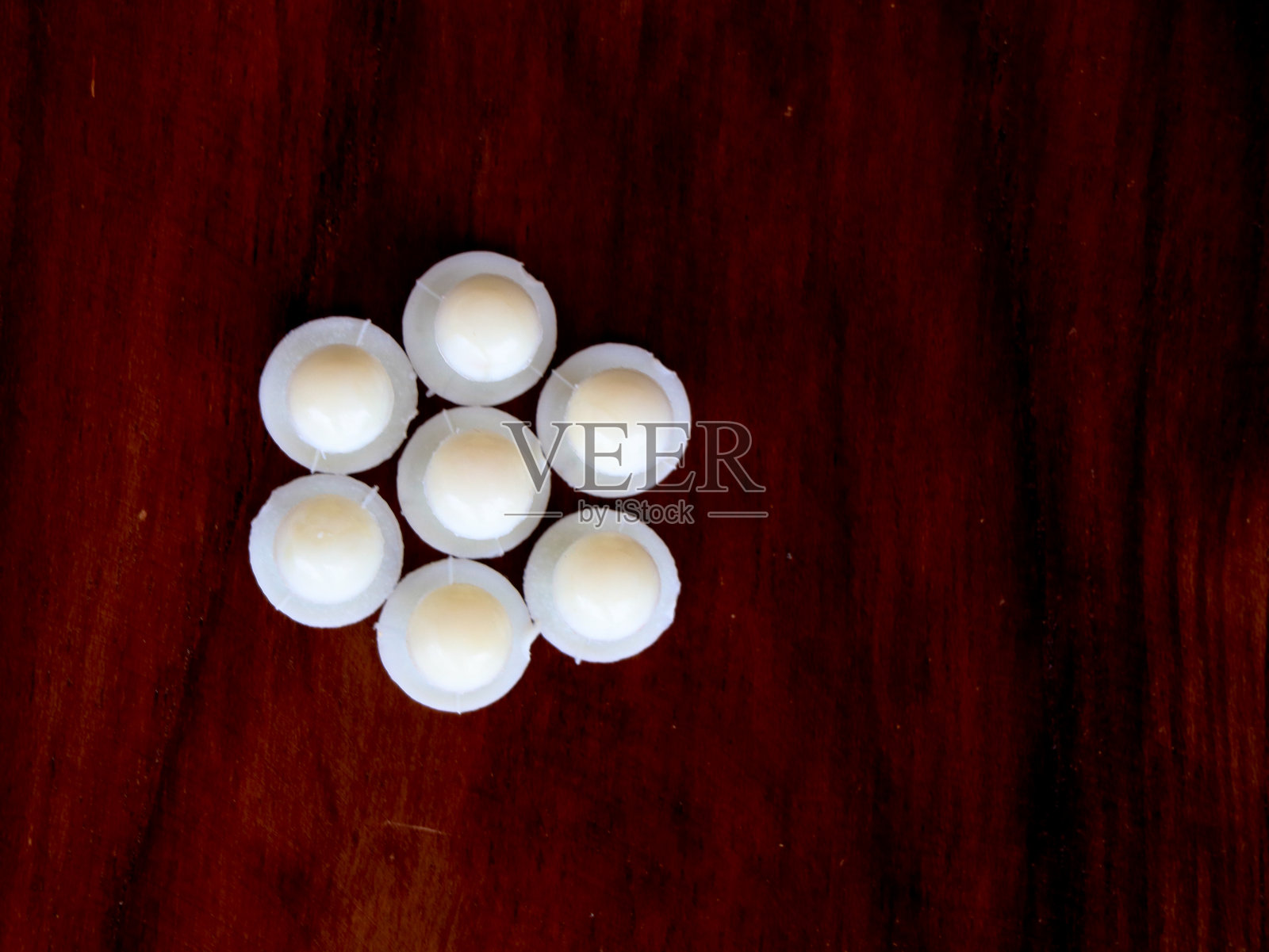 白色的袈裟纽扣映衬着木质的背景照片摄影图片