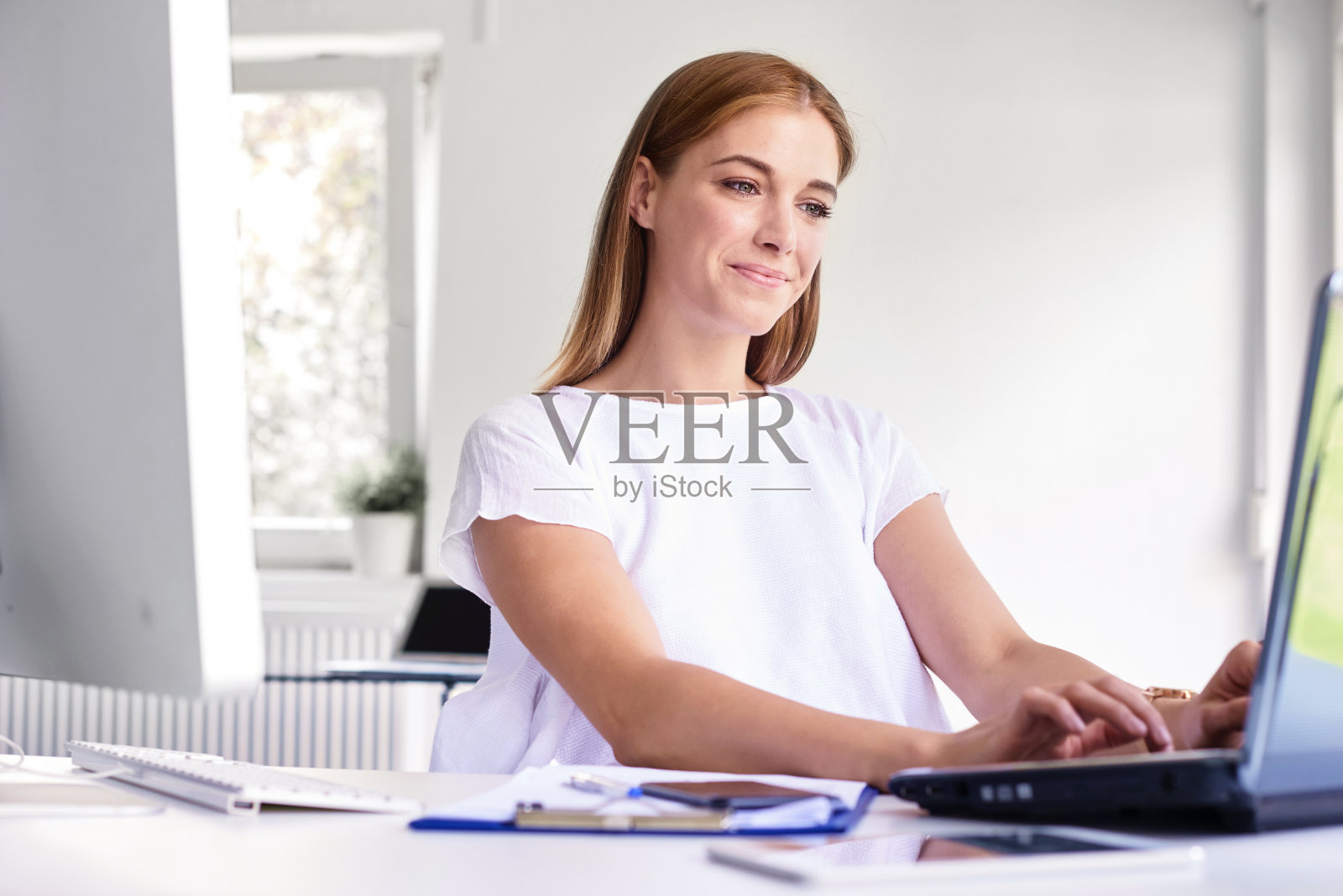 用笔记本电脑工作的年轻职业女性照片摄影图片