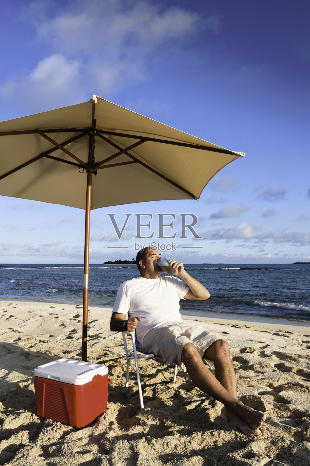 下午晚些时候，一个成熟的男人悠闲地坐在加勒比海的热带礁岛上照片摄影图片