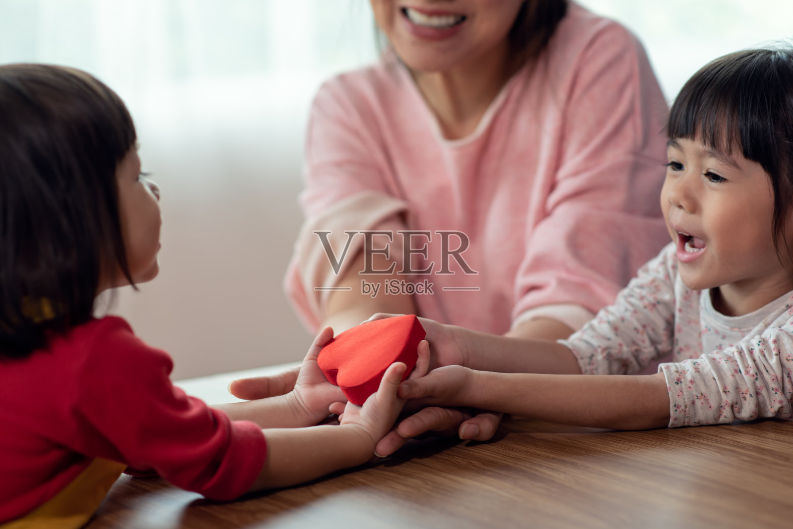 母女手捧红心礼品盒，幸福家庭理念照片摄影图片